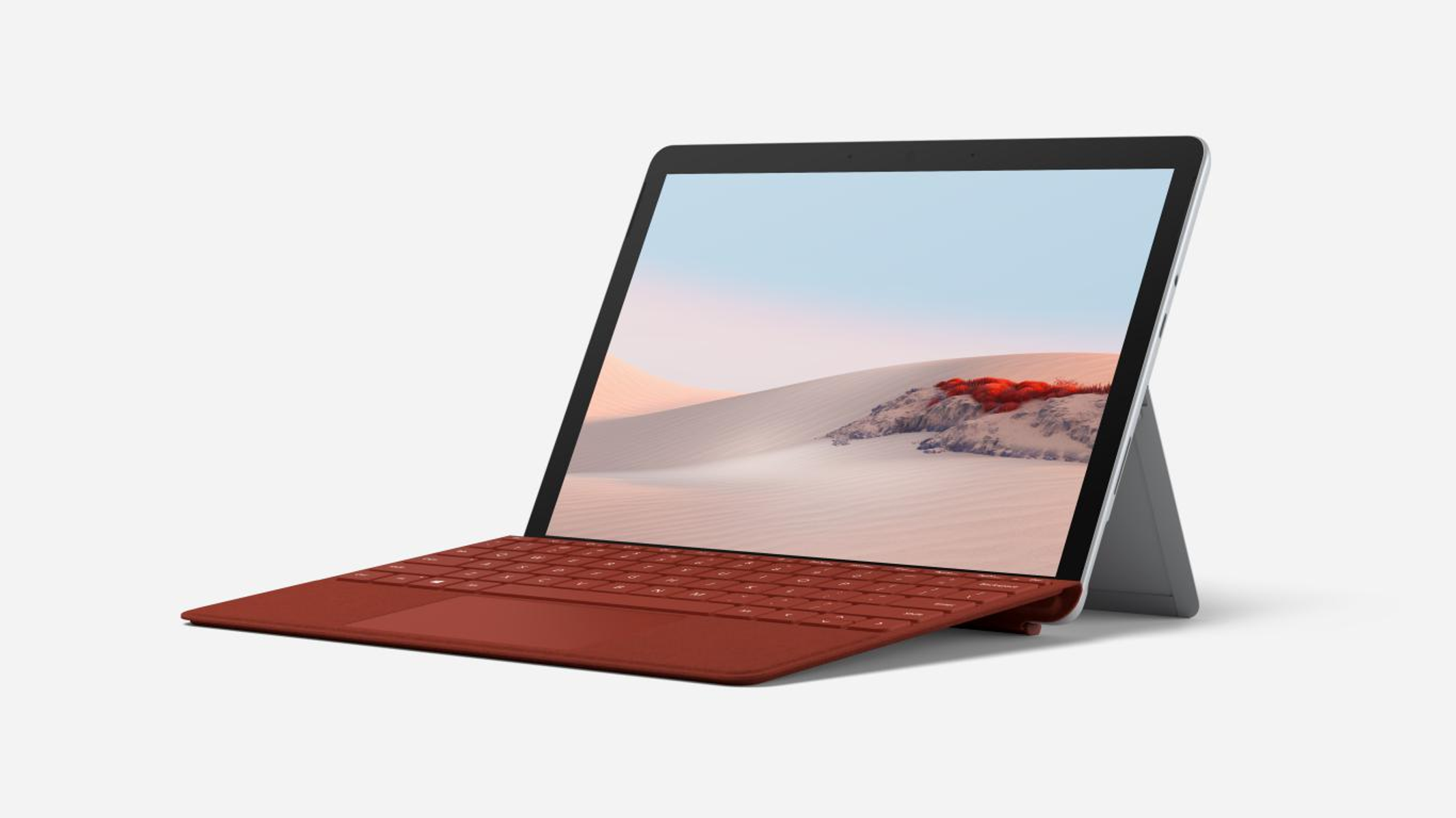 Portátil sobre un soporte, con un teclado rojo y una pantalla que muestra un paisaje.