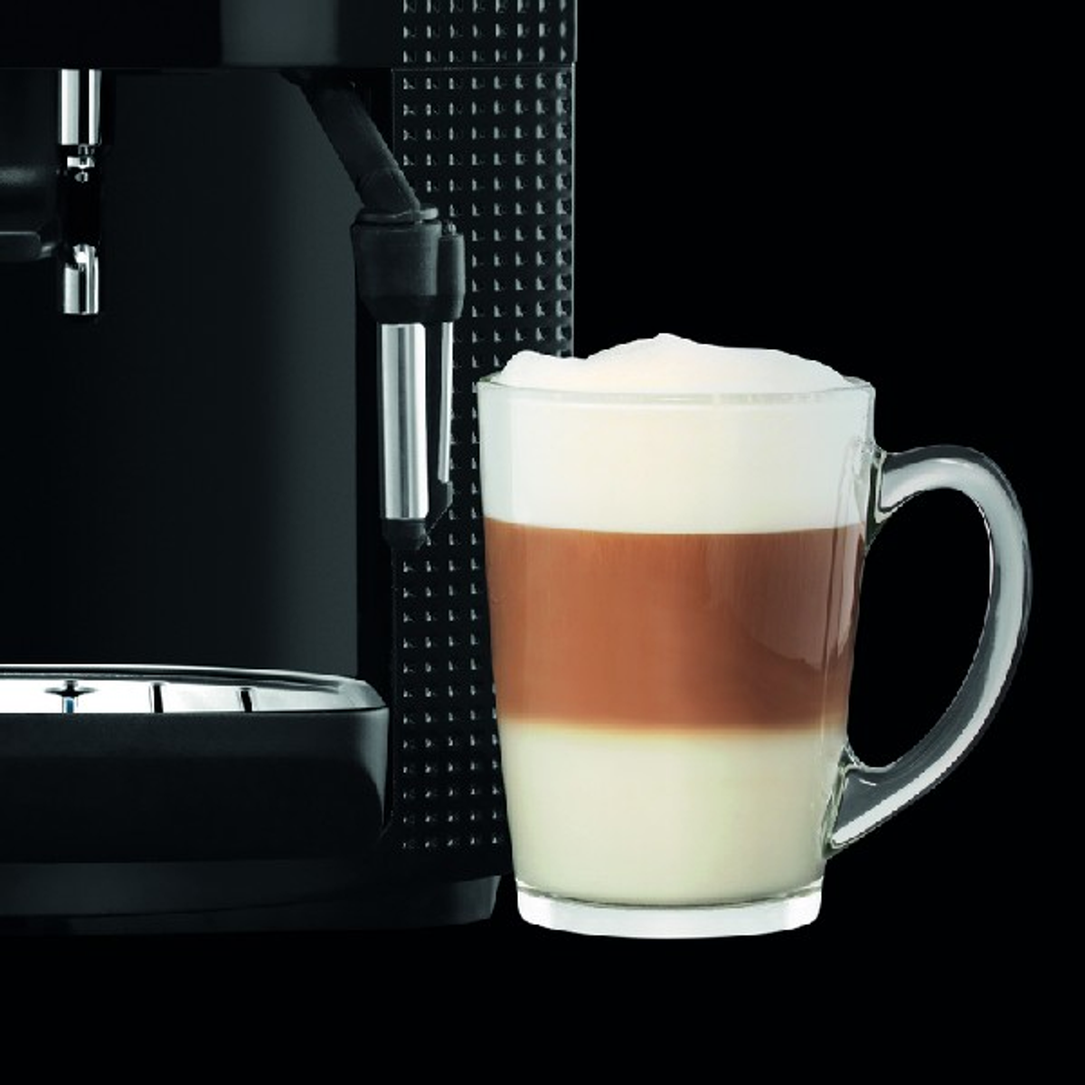 Macchina per il caffè con un latte in un bicchiere. Schiuma di latte sopra, bevanda a strati.