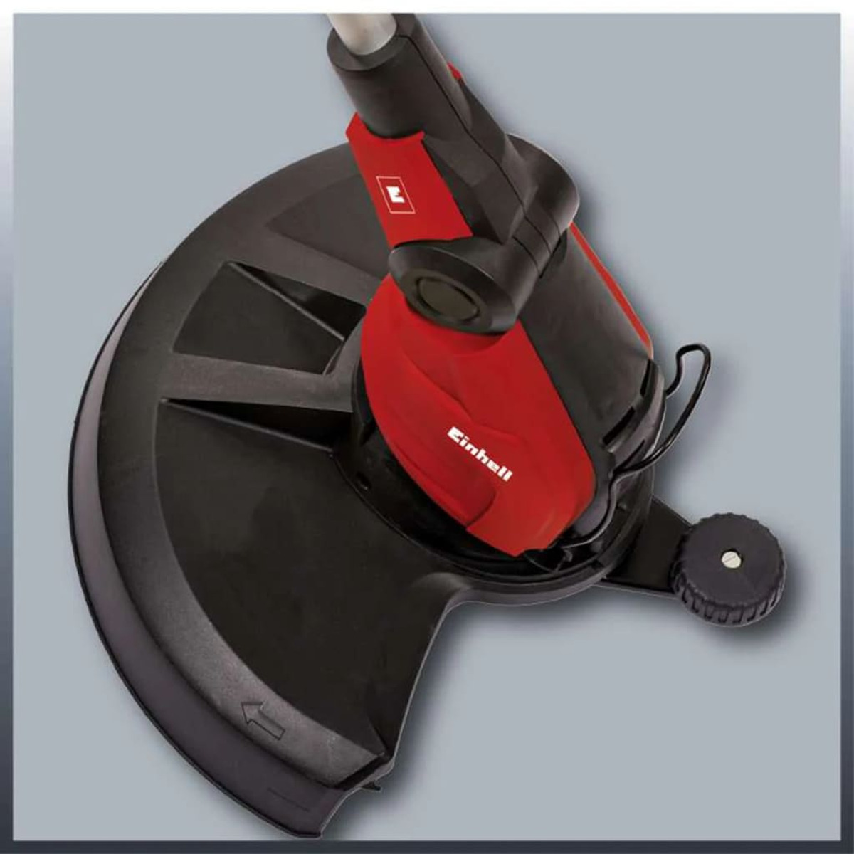 Una recortadora de hilo eléctrica Einhell. Es negra y roja, con un protector negro.