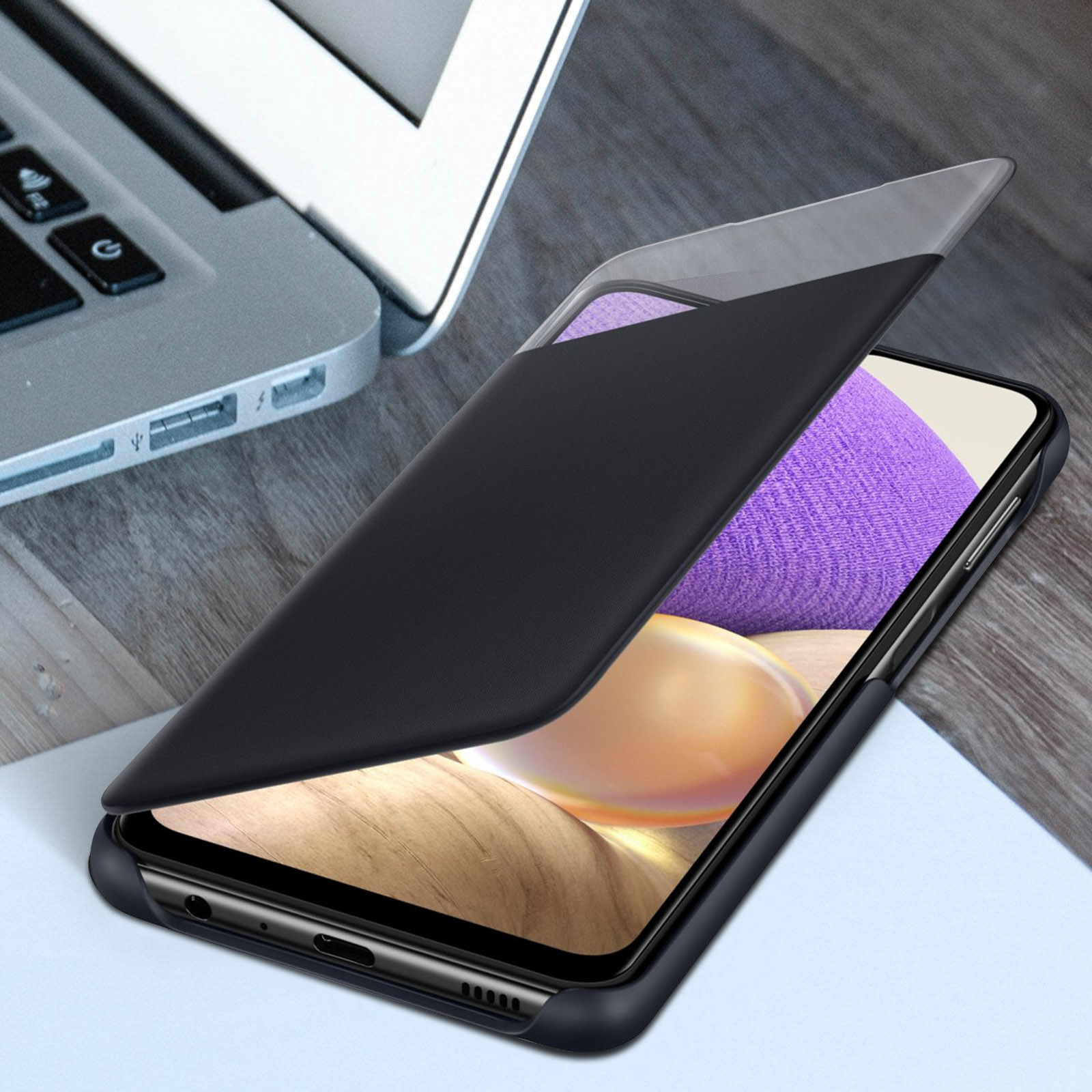 Ein Telefon in einer schwarzen Hülle mit grauem Akzent. Das Telefon liegt auf einem Holztisch.