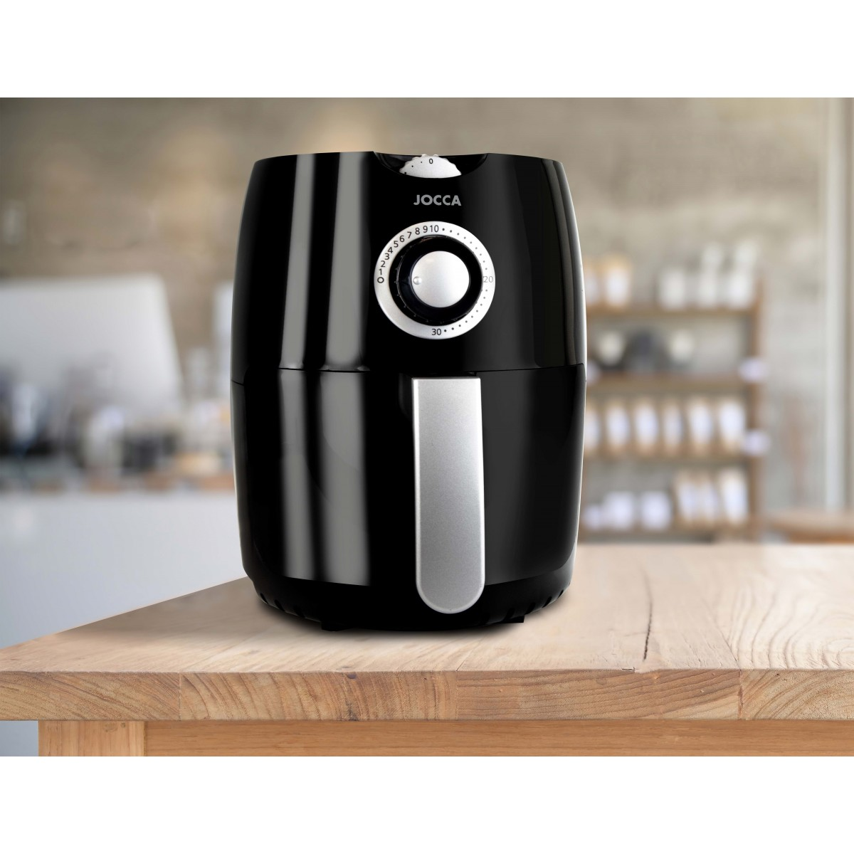 Una friggitrice ad aria nera su un tavolo di legno. La friggitrice ha un display digitale.