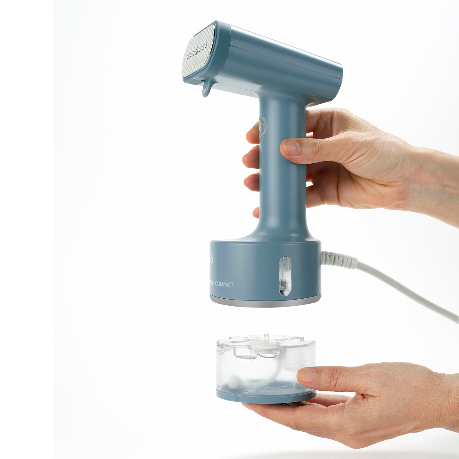 Blauer Kleidungsdampfer, mit abgenommenem Wasserbehälter. Von zwei Händen gehalten.