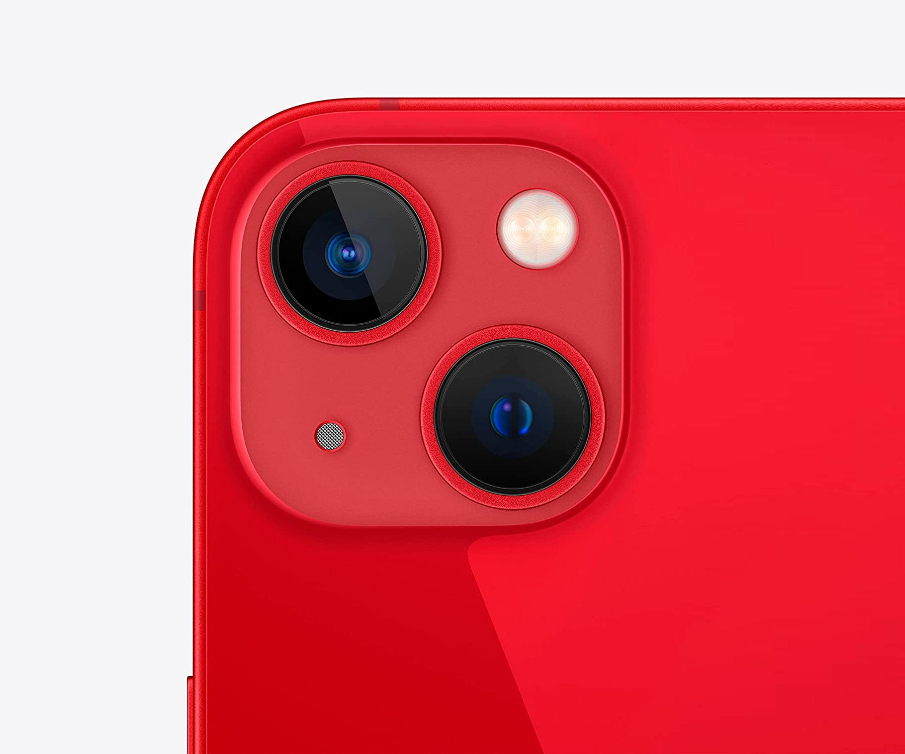 Zbliżenie modułu aparatu czerwonego smartfona. Zawiera dwa obiektywy, lampę błyskową i mikrofon na czerwonej powierzchni. Białe tło.