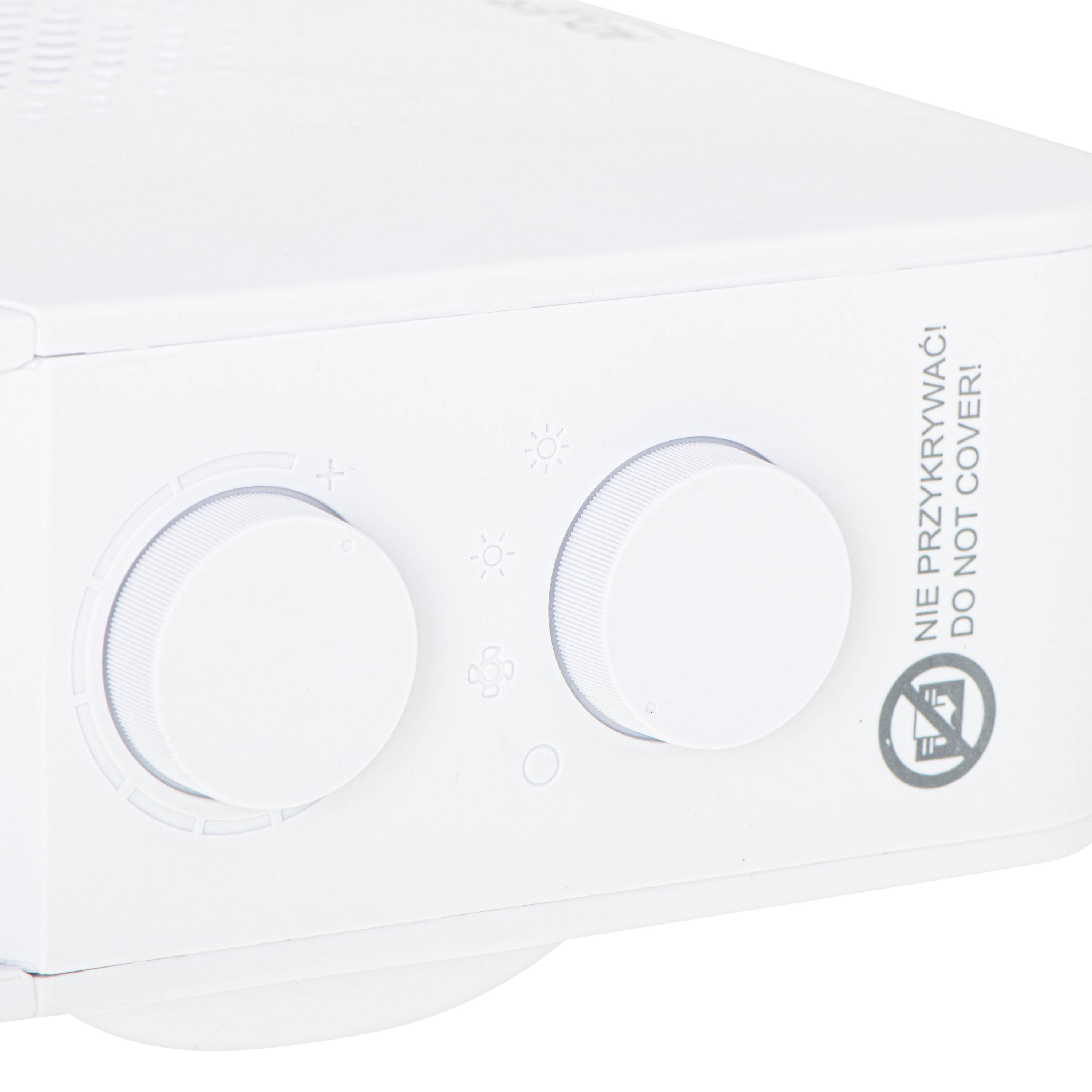 Białe urządzenie z dwoma pokrętłami i tekstem. Tekst ostrzega, aby nie zakrywać urządzenia.