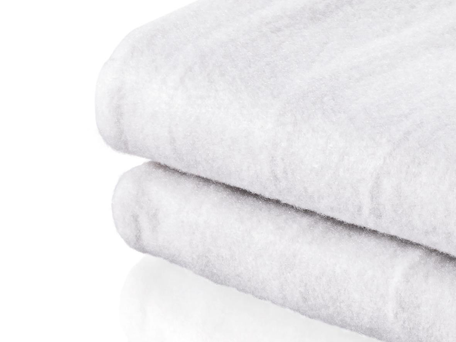 Dwa złożone białe koce. Koce są puszyste i ułożone jeden na drugim.