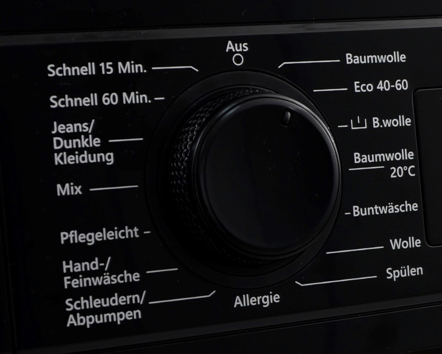 Nahaufnahme eines schwarzen Waschmaschinen-Bedienfelds mit verschiedenen Waschzyklus-Optionen.