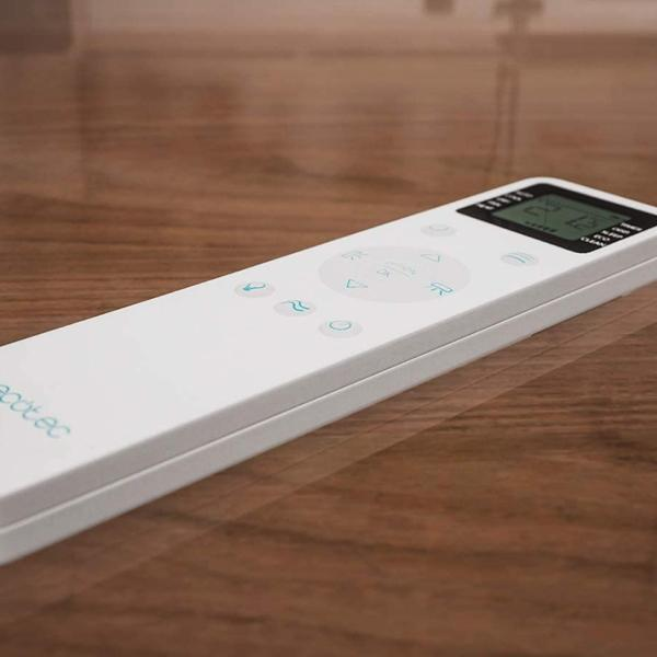 Telecomando bianco su una superficie in legno. Con pulsanti con icone e display digitale.