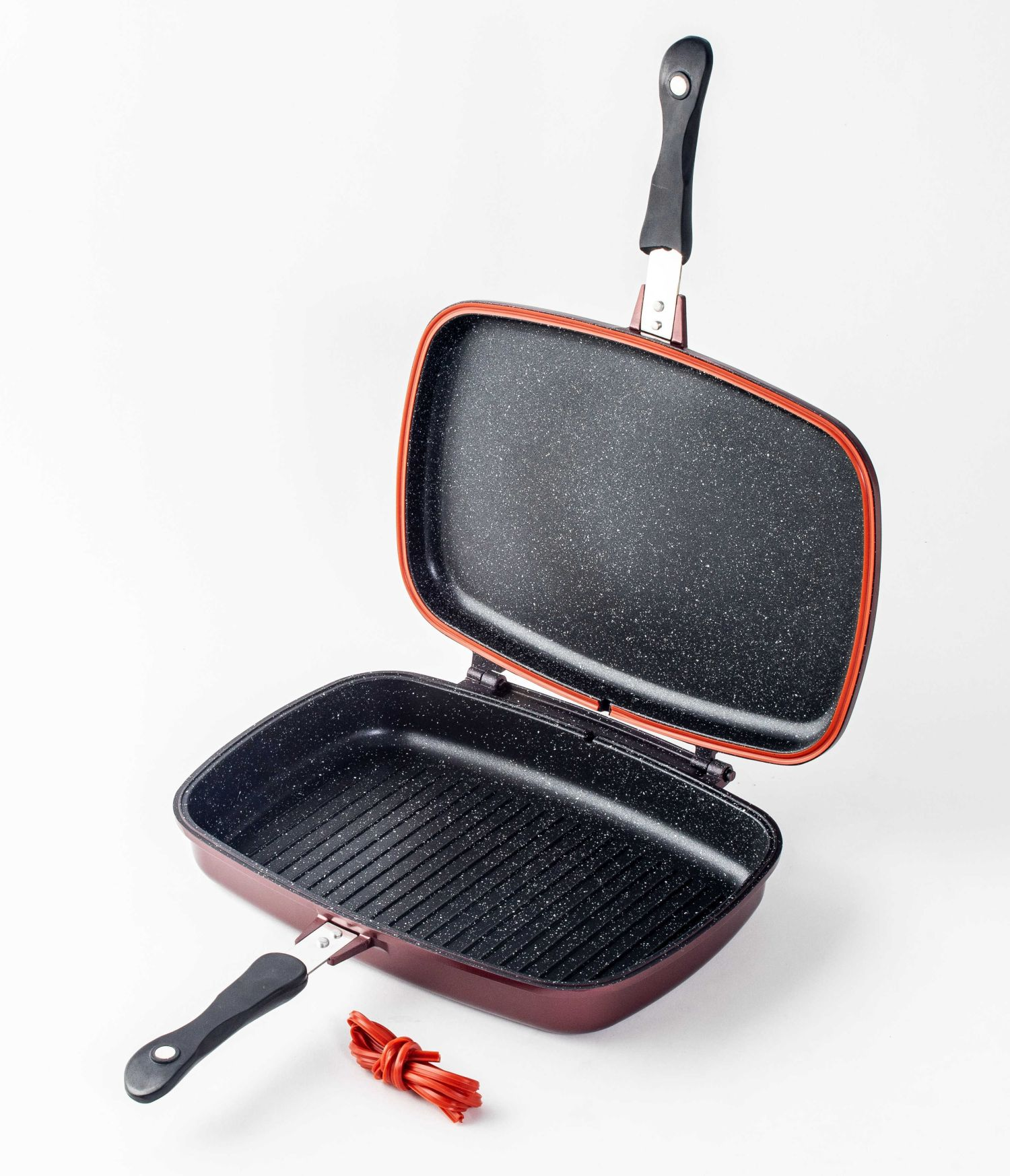 Geöffnete rote und schwarze Antihaft-Bratpfanne mit rotem Gummiband.