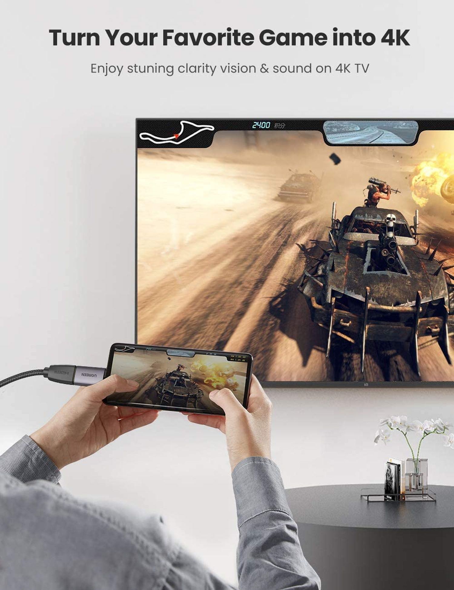 Person hält Telefon, das mit Fernseher verbunden ist, der Spiel zeigt.