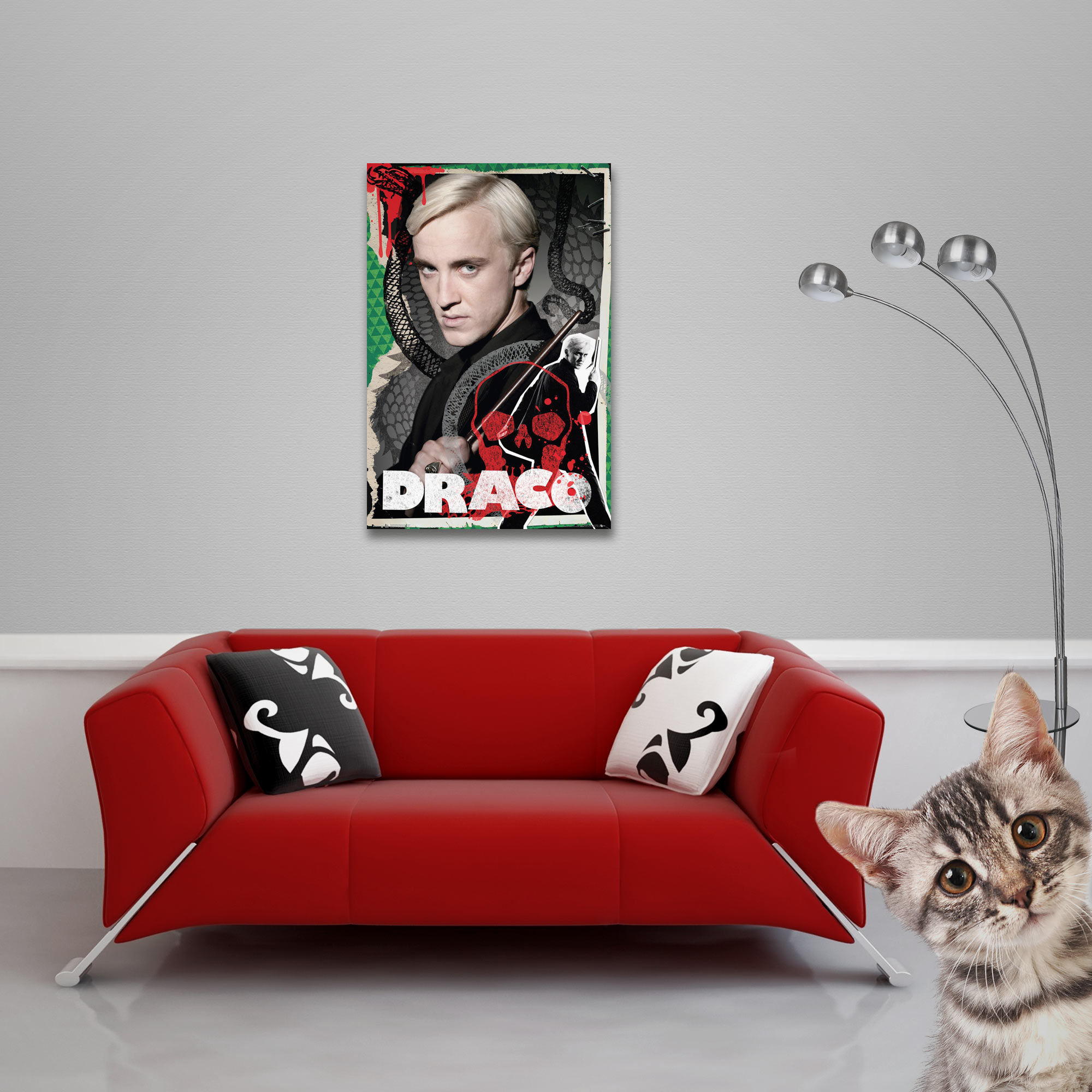 Ein Poster von Draco Malfoy, ein rotes Sofa, zwei Kissen, eine Katze und eine Stehlampe vor einer grauen Wand.