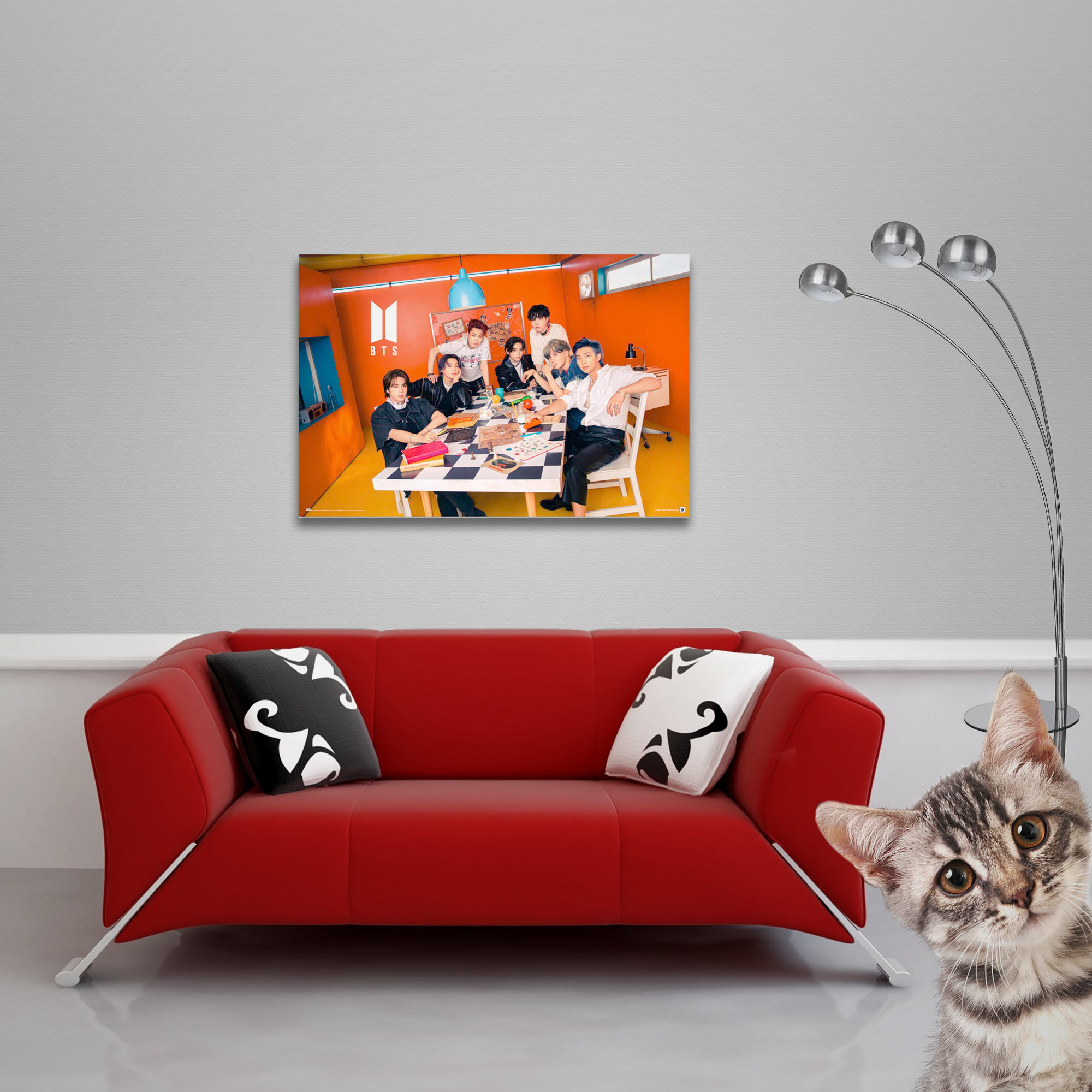 Ein BTS-Poster an der Wand. Rotes Sofa, Katze und Stehlampe im Raum.
