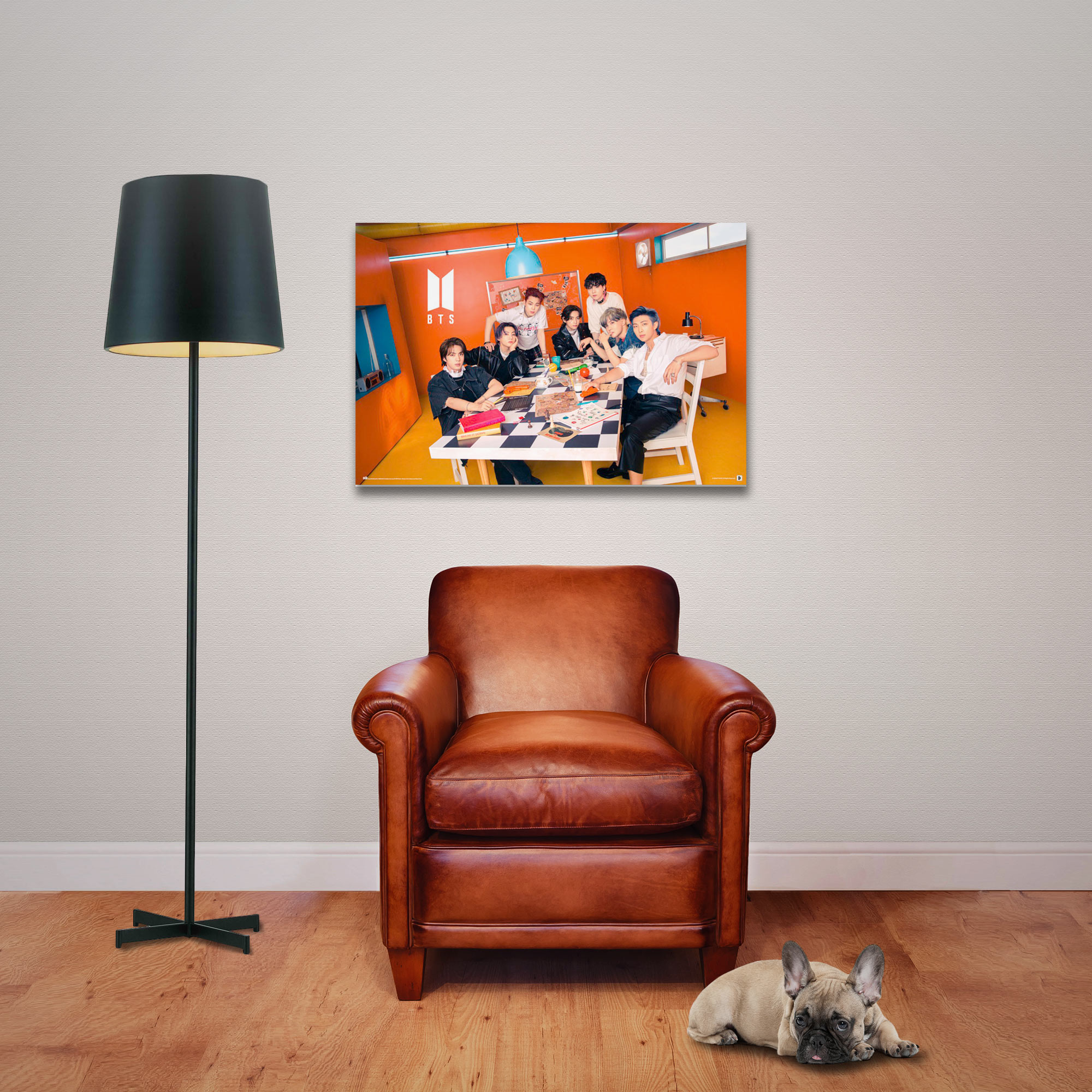 Eine Gruppe von Leuten versammelt sich um einen Tisch, ein großes Poster von ihnen hängt an der Wand.