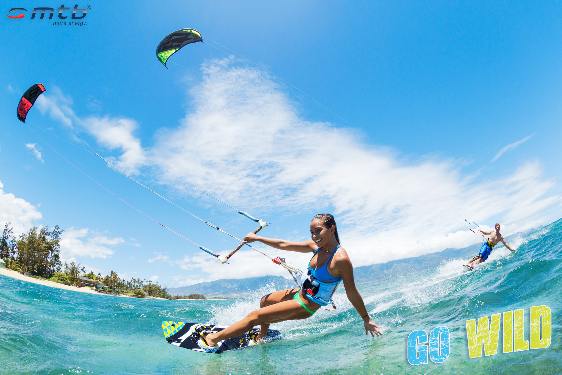 Frau auf Surfbrett, Wasser, Kites am Himmel und die Worte GO WILD.