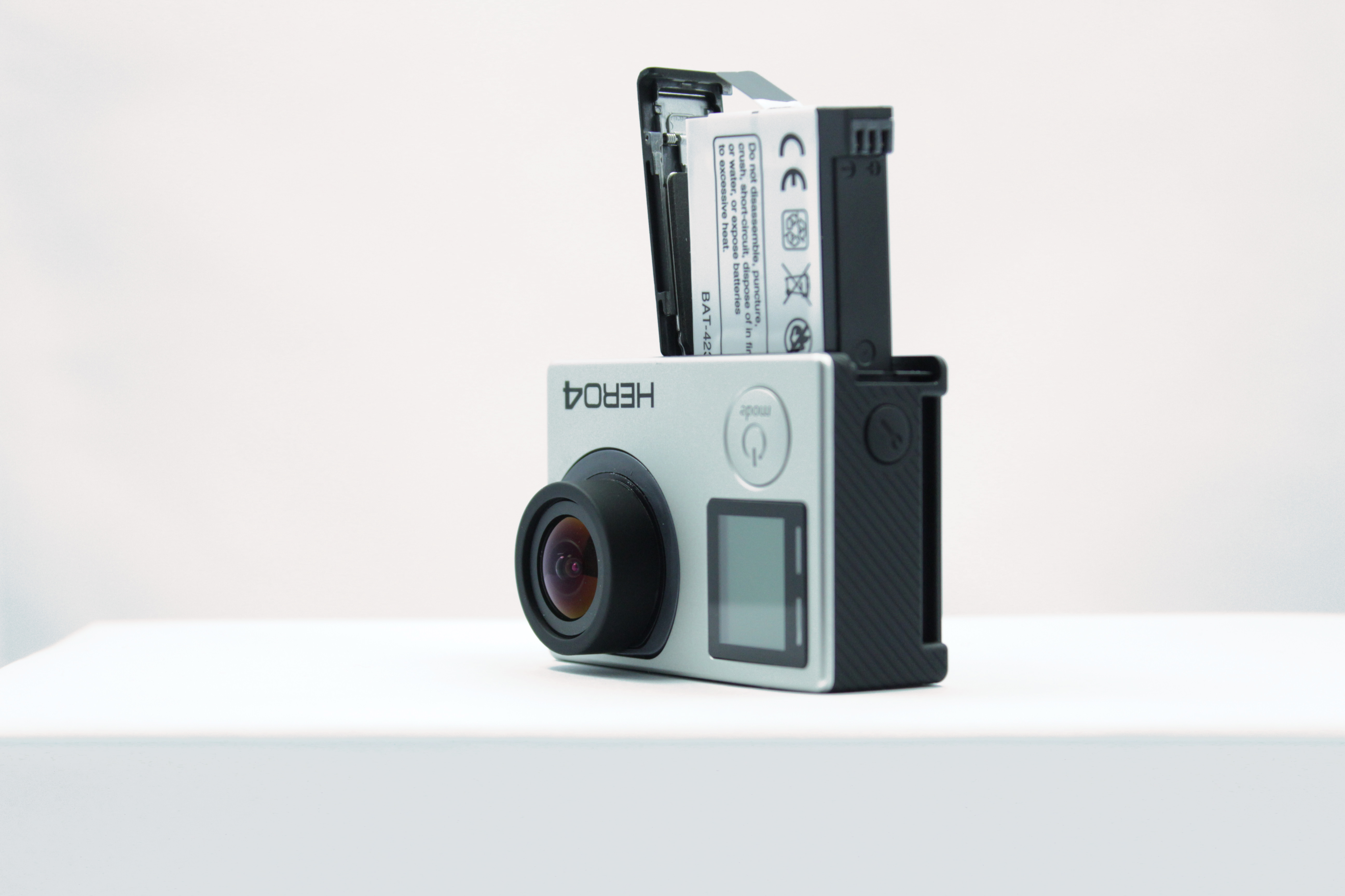 Eine GoPro-Kamera mit geöffnetem Batteriefach, das die Batterie freilegt.