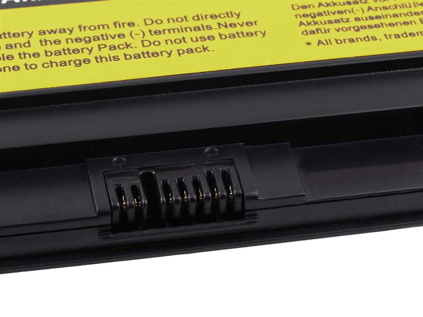 Primer plano del conector de una batería de portátil negra. Etiqueta de advertencia amarilla visible.