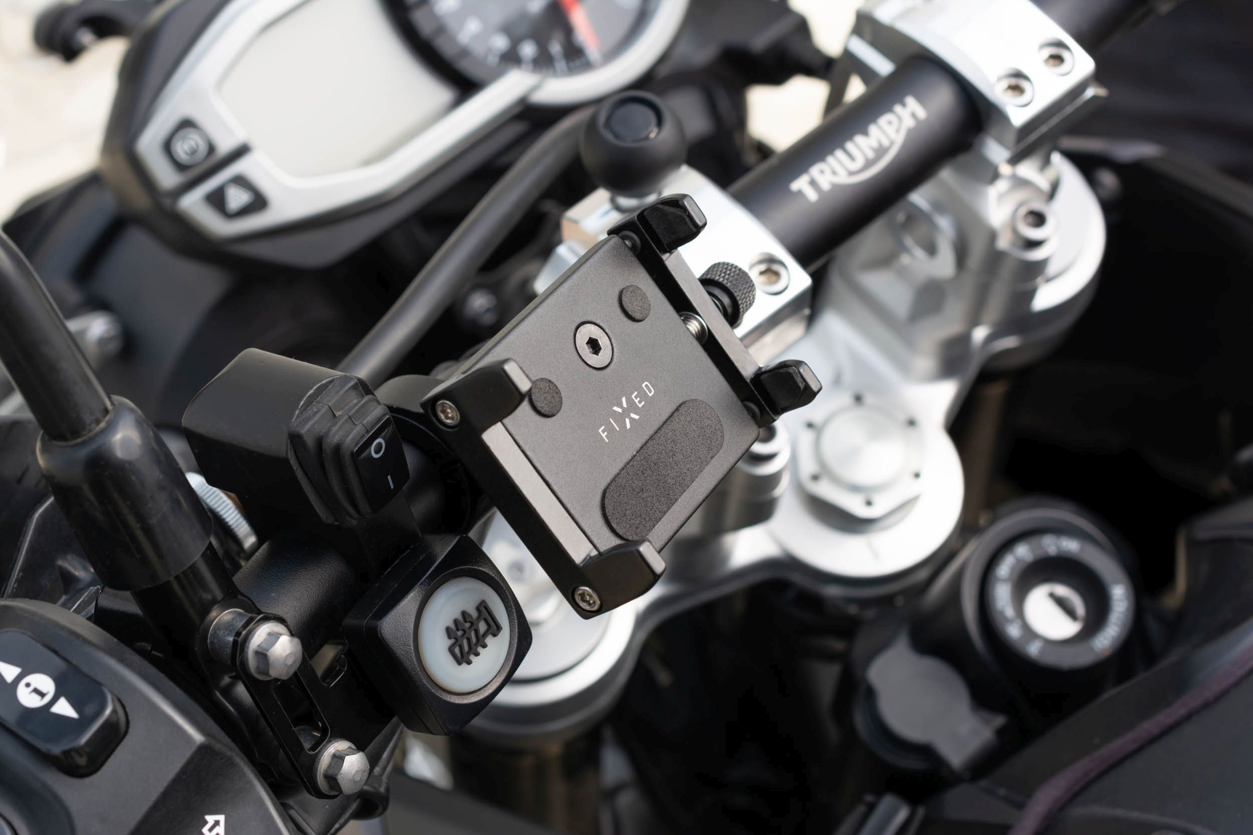 Motorradlenker mit Handyhalterung, Schlüssel und anderen Bedienelementen.