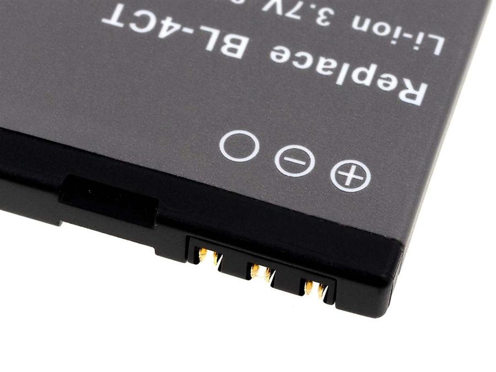 Batería negra con contactos eléctricos y símbolos más/menos. Superficie gris.
