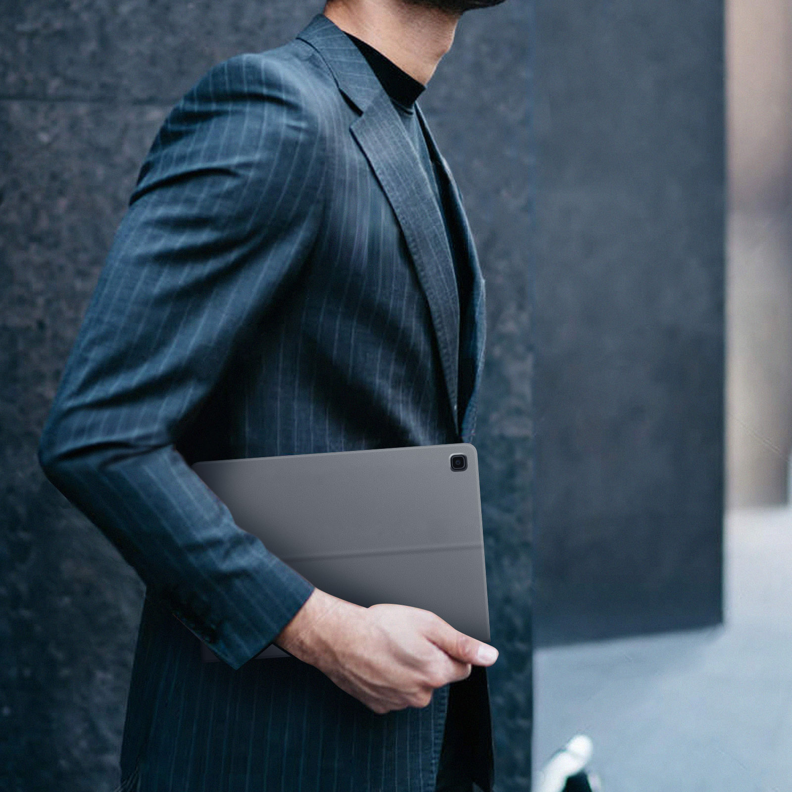 Osoba w garniturze trzymająca tablet.