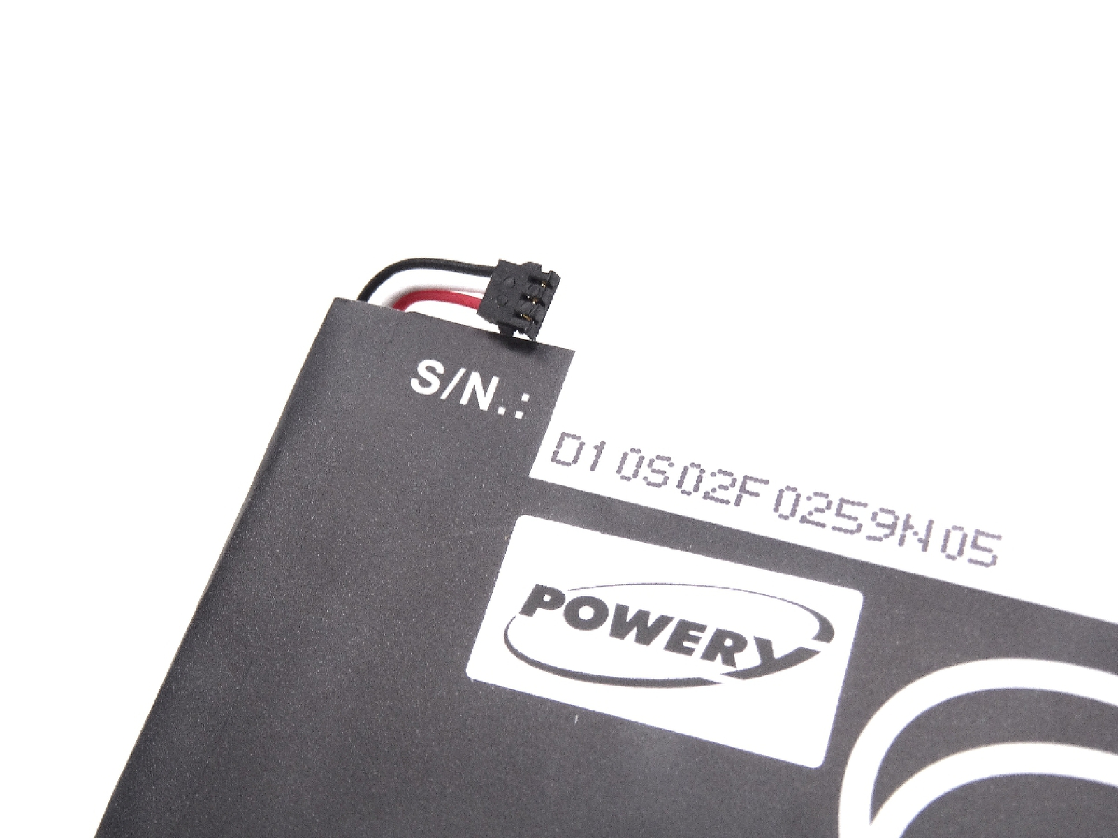 Una batería negra con una pegatina blanca y un conector.