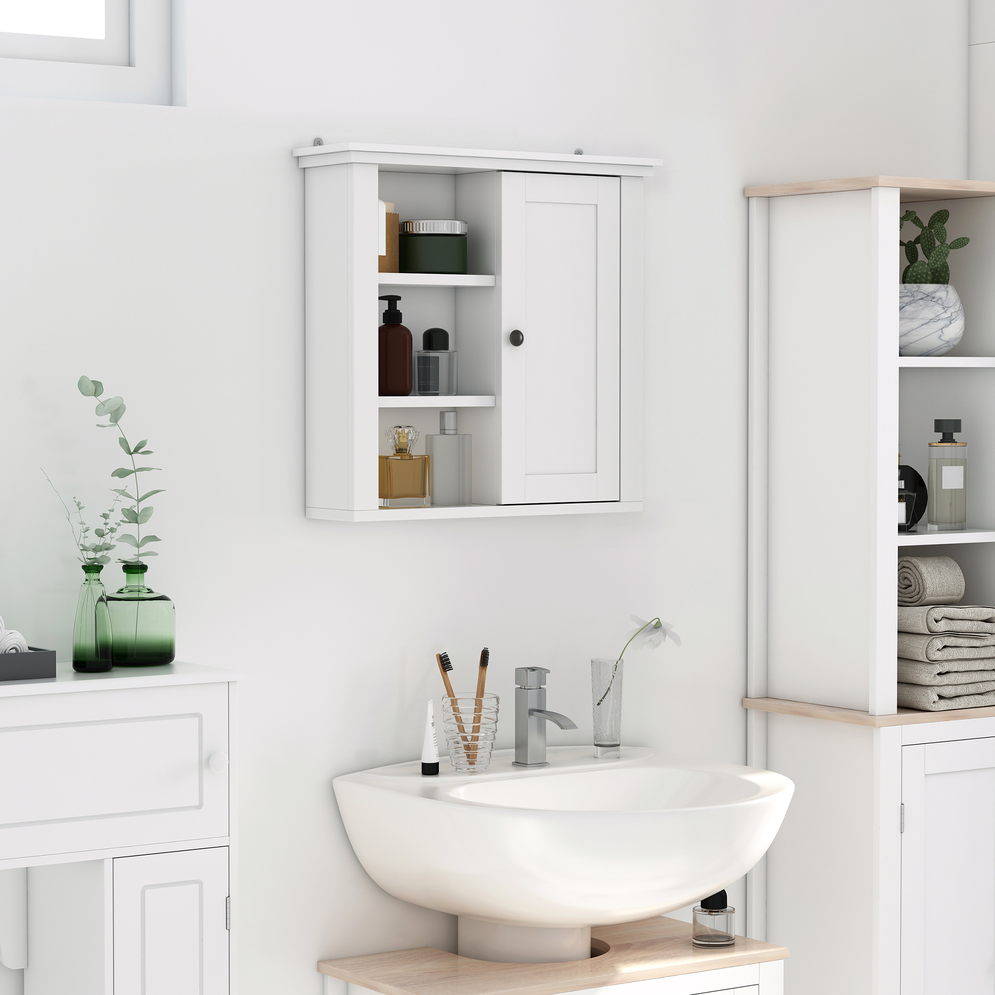 Un mueble de baño blanco sobre un lavabo con grifos y plantas.