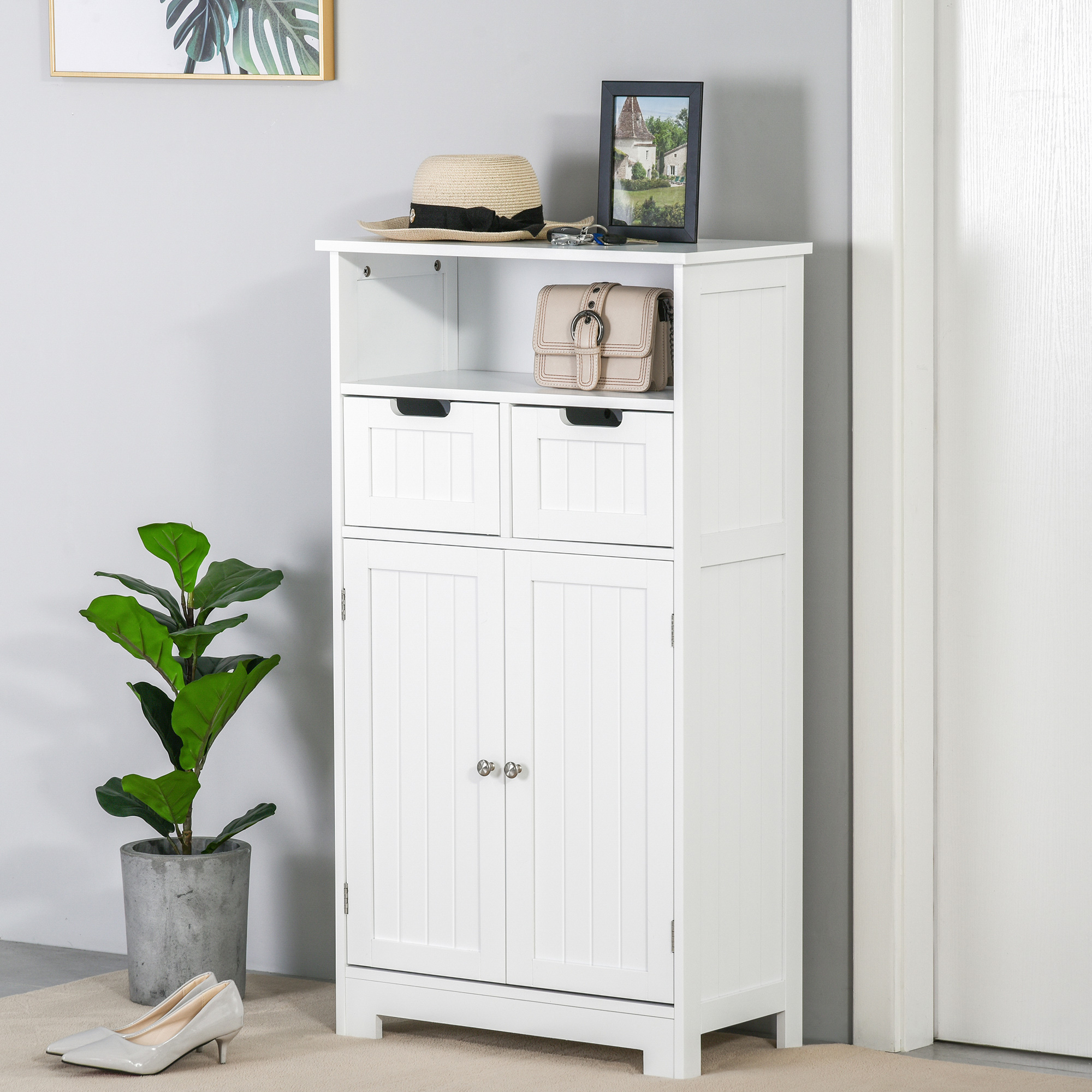 Un armario blanco con puertas y cajones, al lado una planta y zapatos.