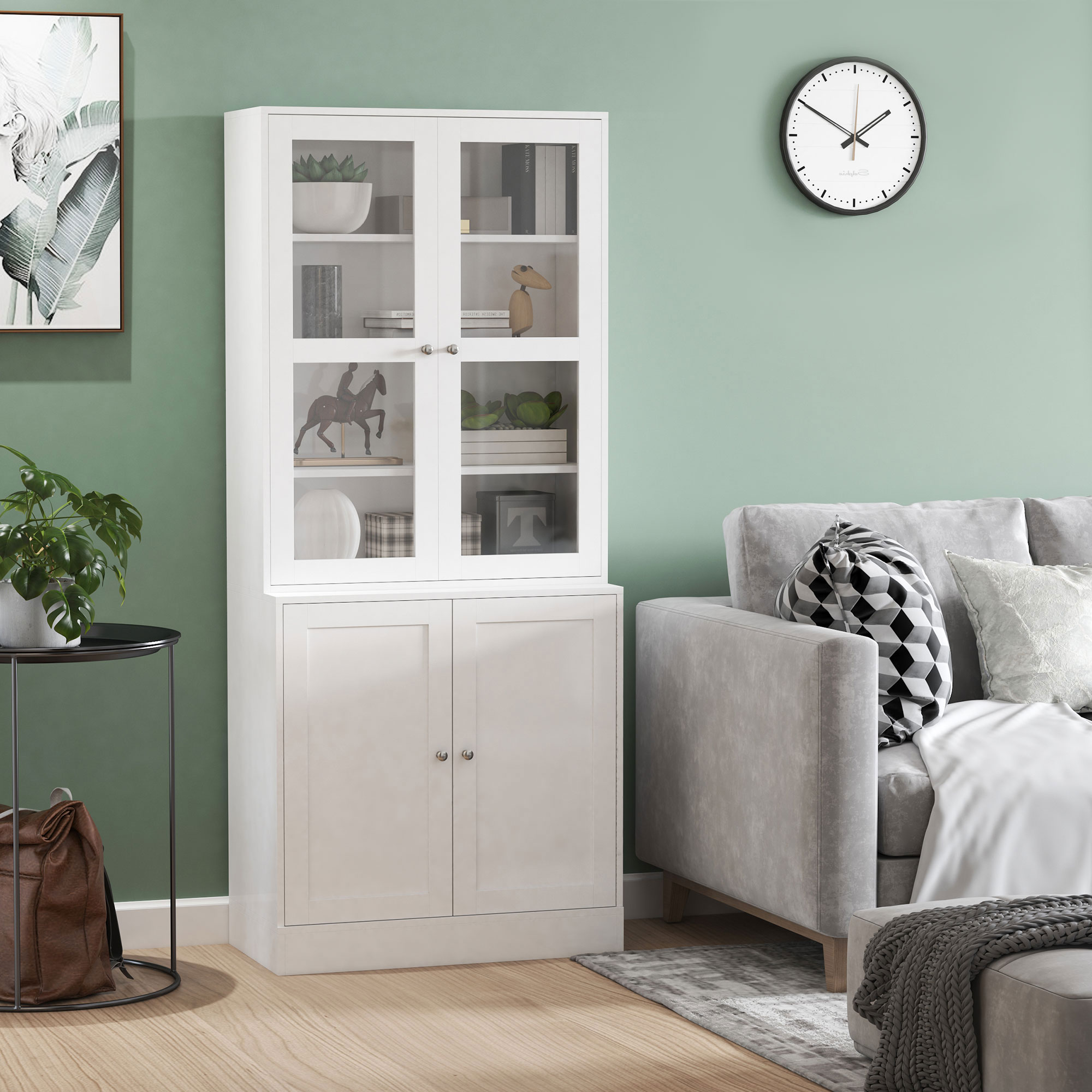 Un mueble blanco con puertas de cristal junto a un sofá gris. Una planta en una mesa auxiliar.
