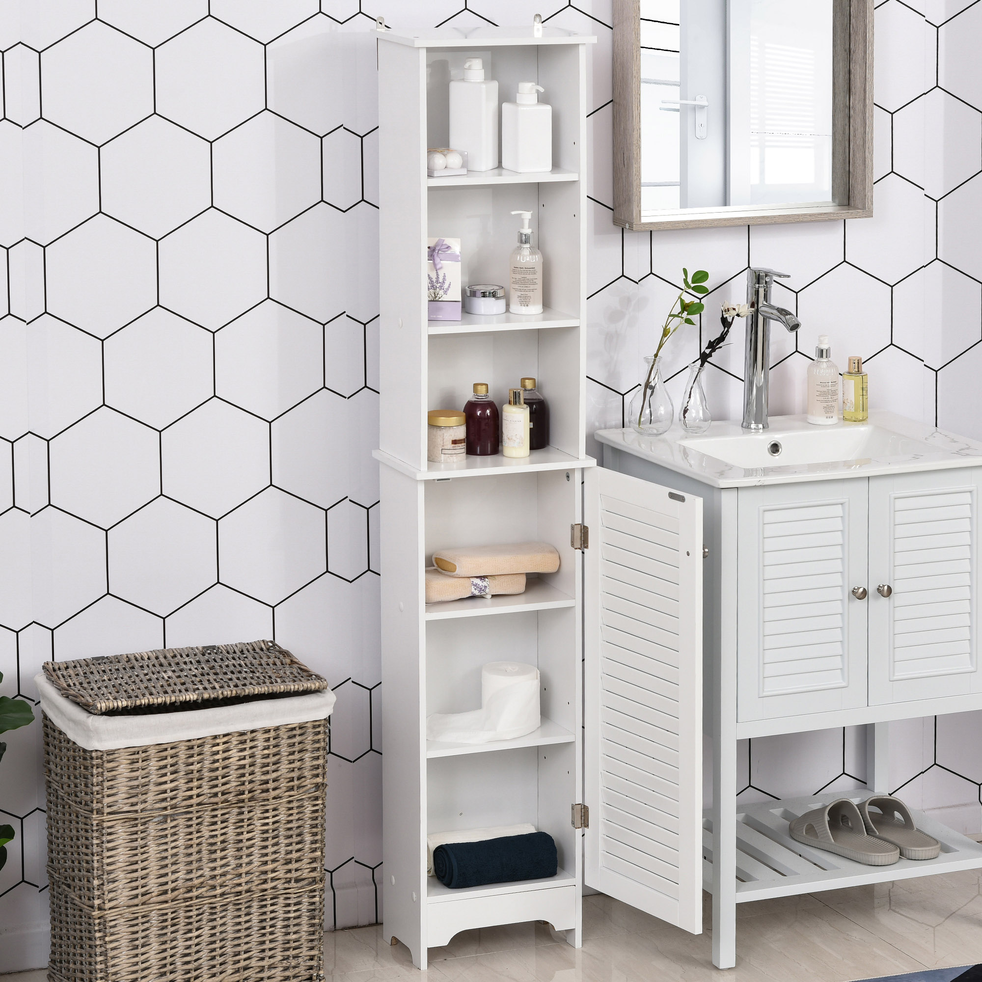 Un armario de baño blanco con estantes abiertos y una puerta, junto a un lavabo y una cesta de lavandería.