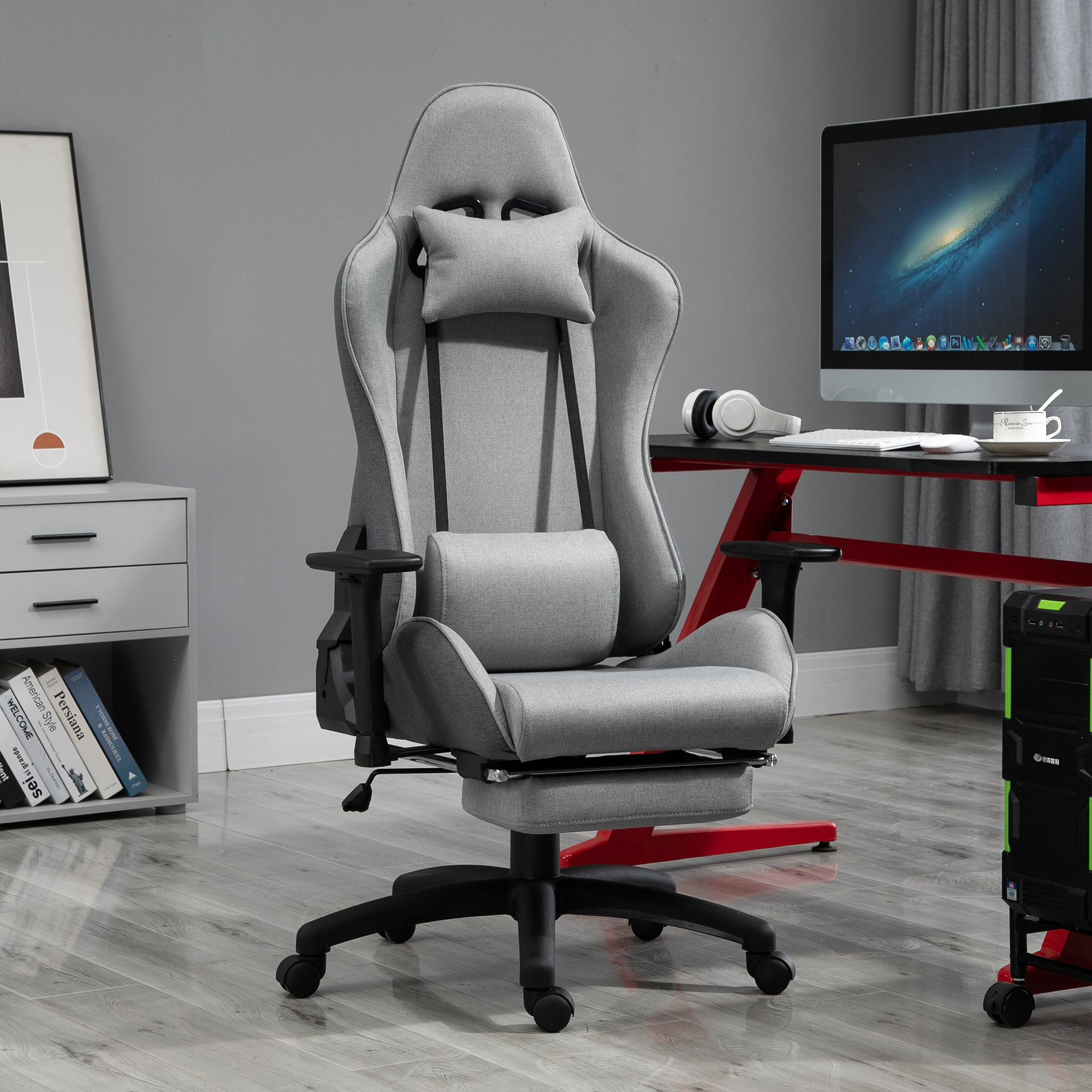 Ein grauer Gaming-Stuhl steht vor einem Schreibtisch mit Computer, Tastatur und Kopfhörern.