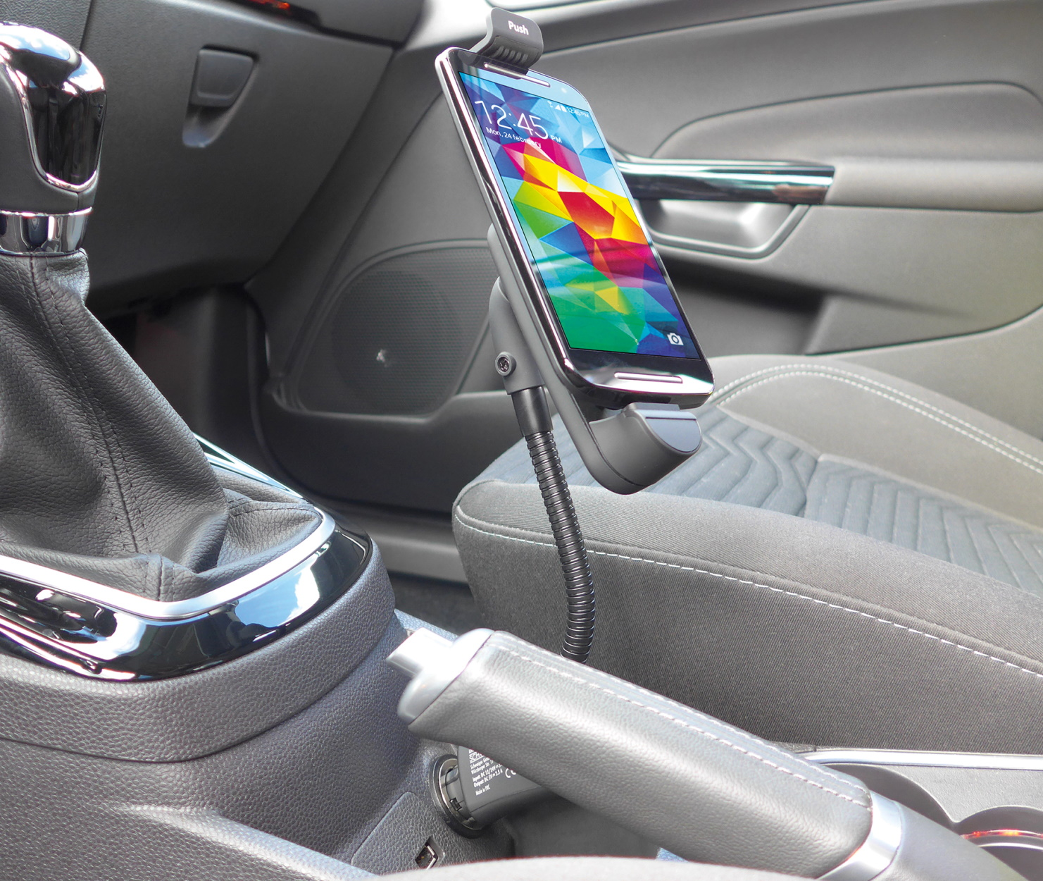 Ein Smartphone in einer Autotelefonhalterung. Der Innenraum des Autos ist sichtbar. Natürliches Licht im Hintergrund.