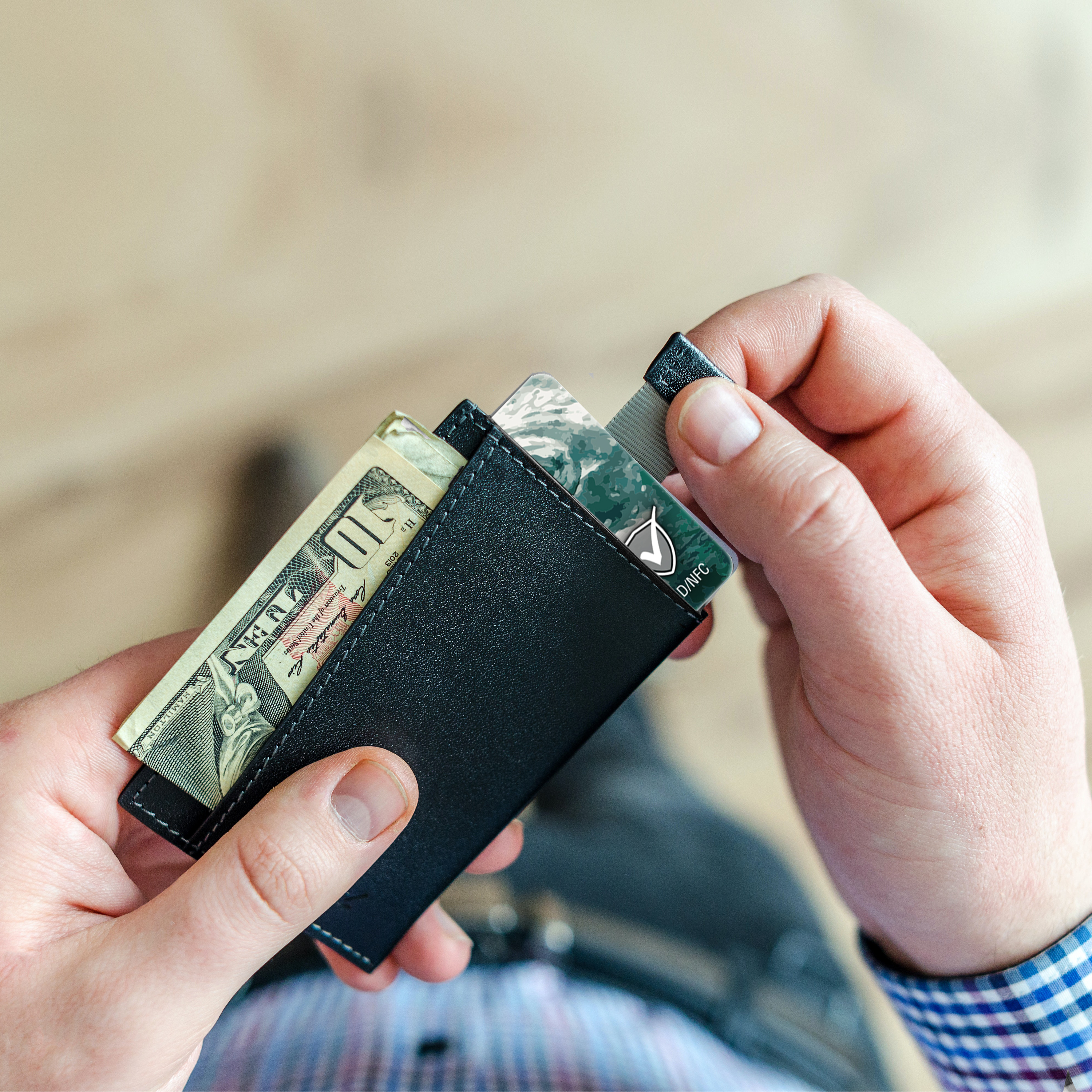 Hände einer Person halten eine Geldbörse mit Bargeld und Karten, teilweise sichtbar.