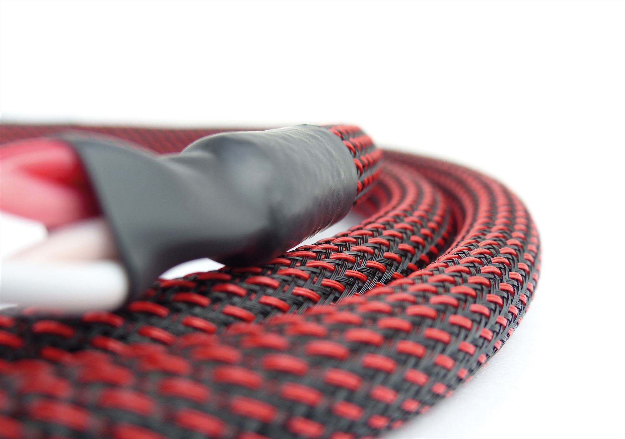 Rot-schwarzes geflochtenes Kabel mit schwarzem Stecker und weißem Hintergrund.