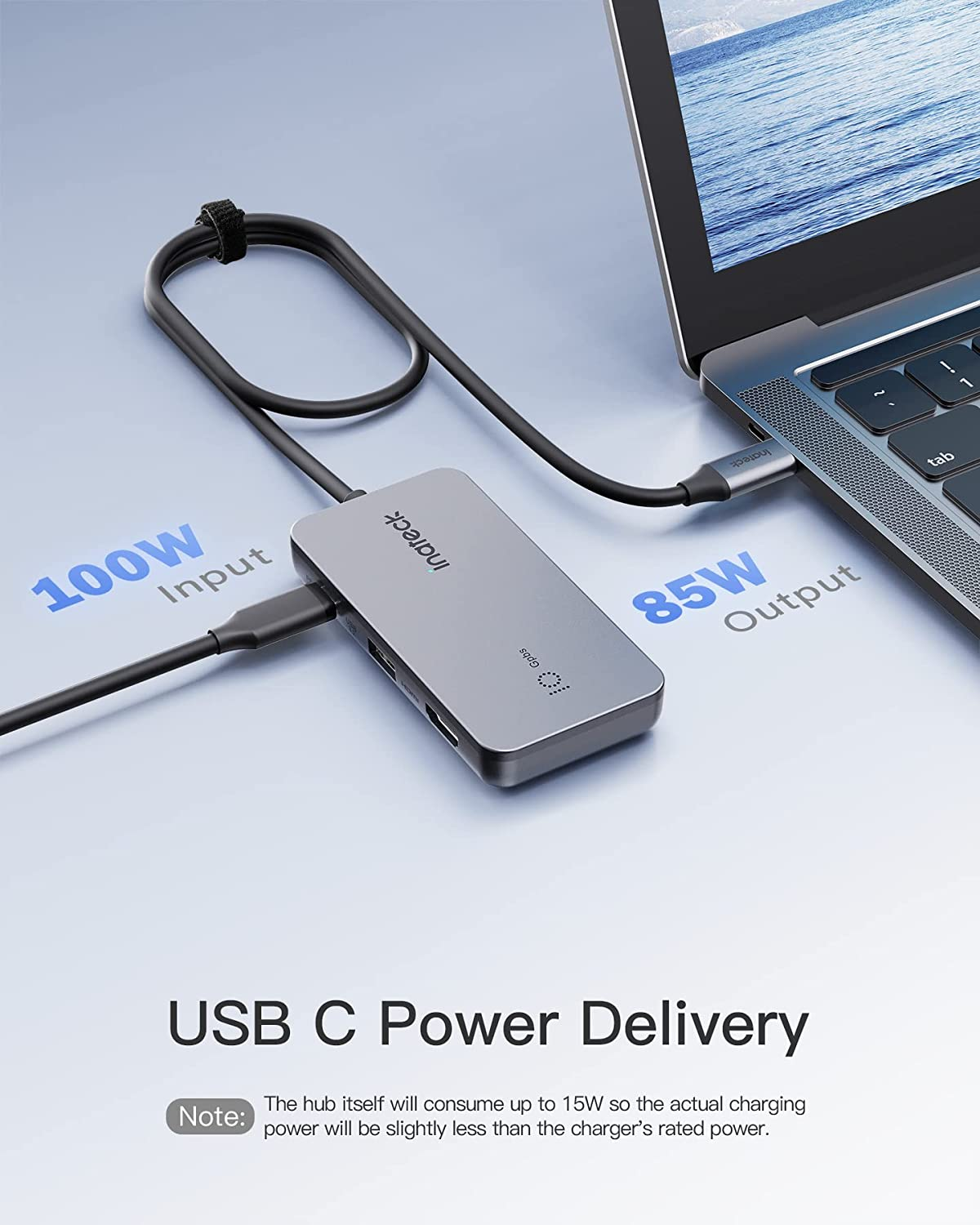 Ein silberner USB-C-Hub, der mit einem Laptop verbunden ist. Text zeigt 100W Eingang und 85W Ausgangsleistung an.