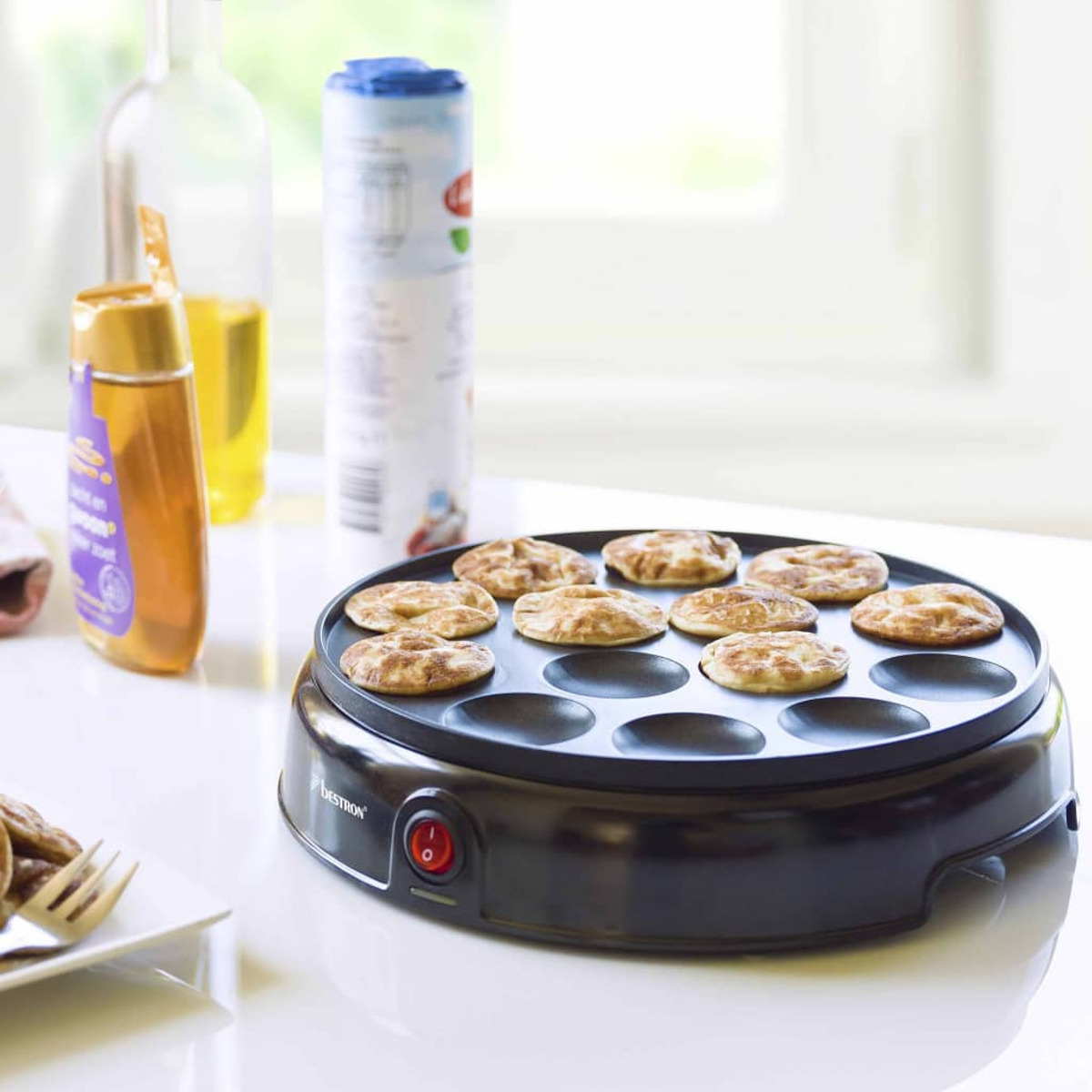 Maszyna do naleśników z upieczonymi naleśnikami, butelkami i składnikami.