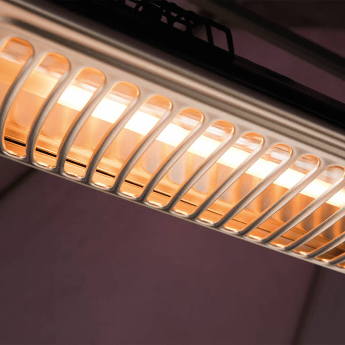 Close-up van een buitenkachel met licht dat uit de elementen komt.