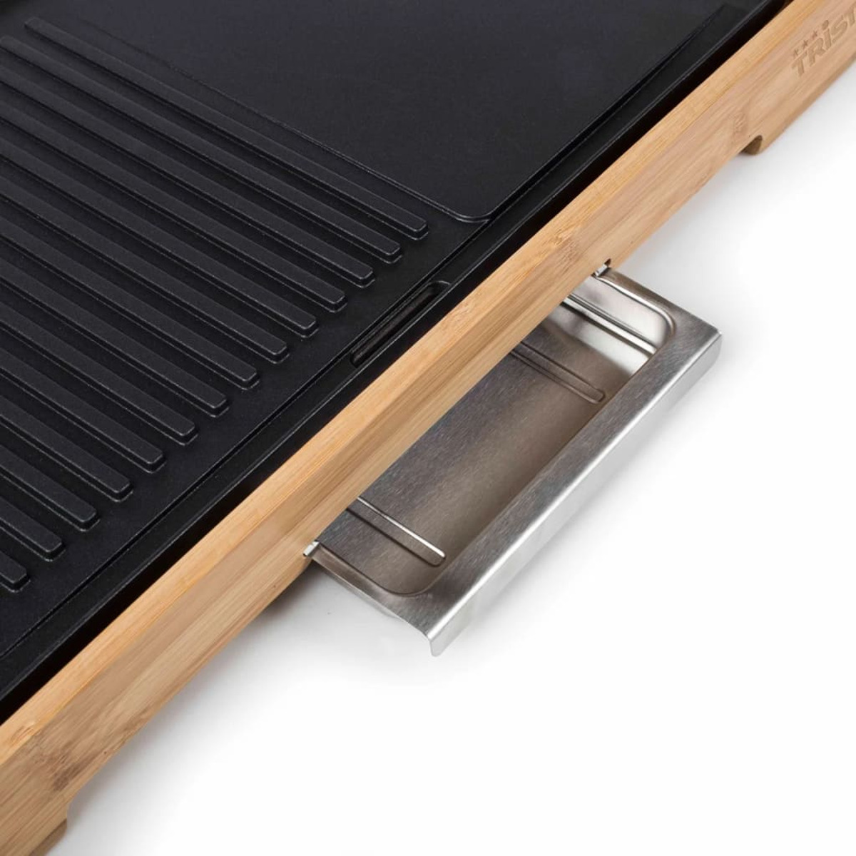 Primo piano di una superficie nera della griglia con scanalature, un telaio in legno e un vassoio raccogli gocce argentato.