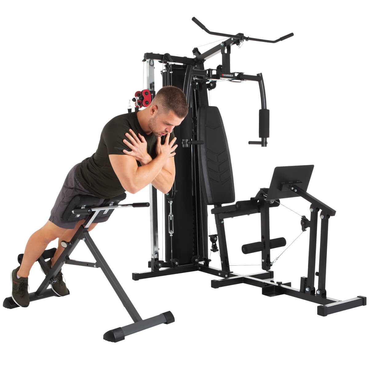 Mann trainiert an einer Multi-Stationen-Fitnessmaschine, schwarz, mit Gewichten und Stangen.