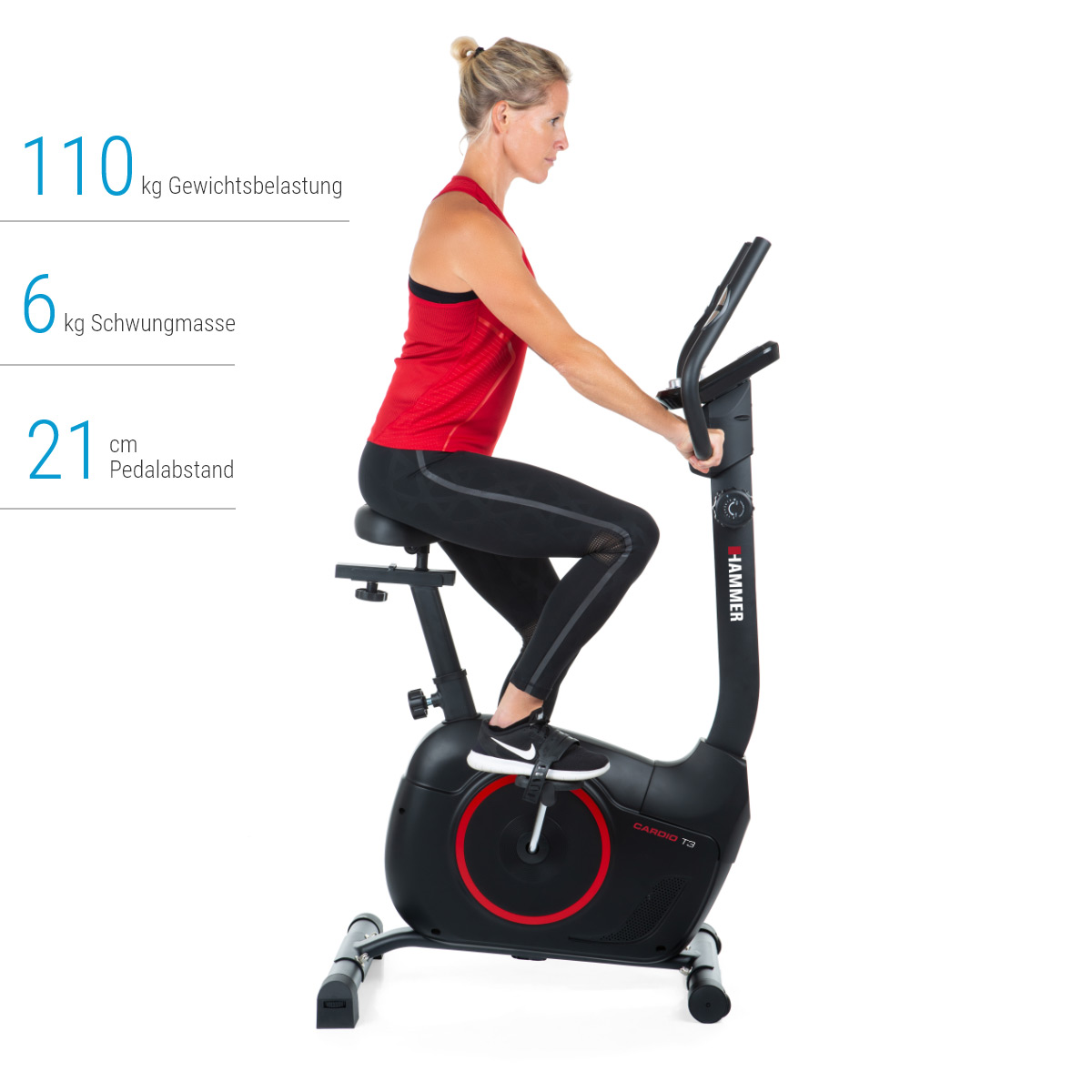 Frau auf einem Heimtrainer. Rotes Oberteil, schwarze Leggings. Schwarzes Fahrrad mit schwarzen Griffen. Weißer Hintergrund.