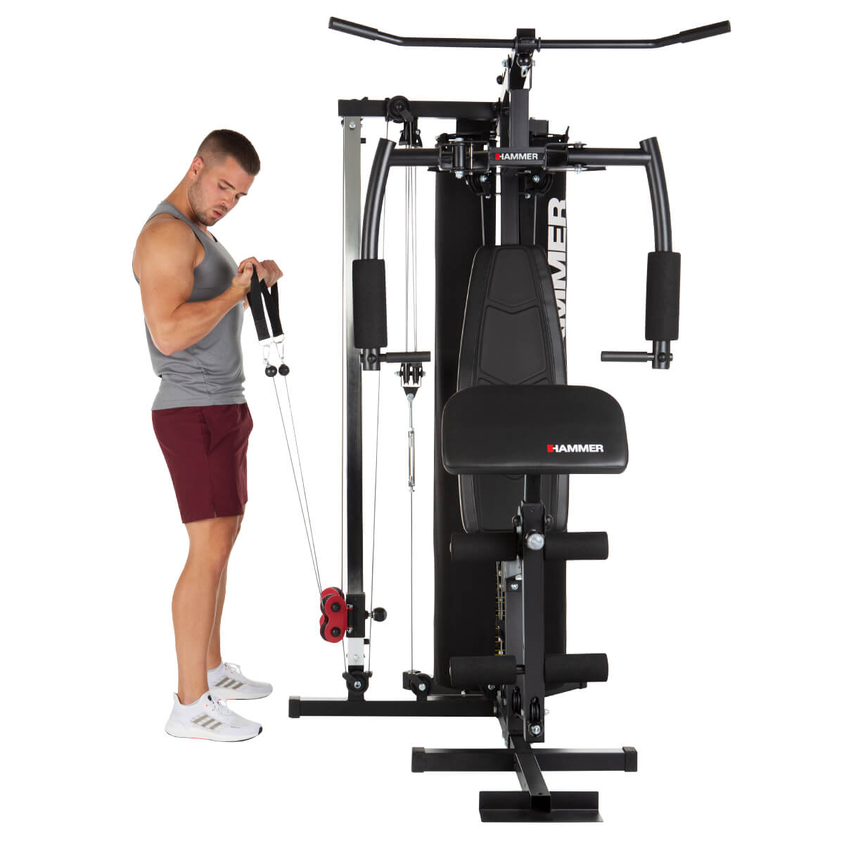 Ein Mann, der ein Home-Gym benutzt und sich auf Armübungen mit einer Kabelzugmaschine konzentriert.