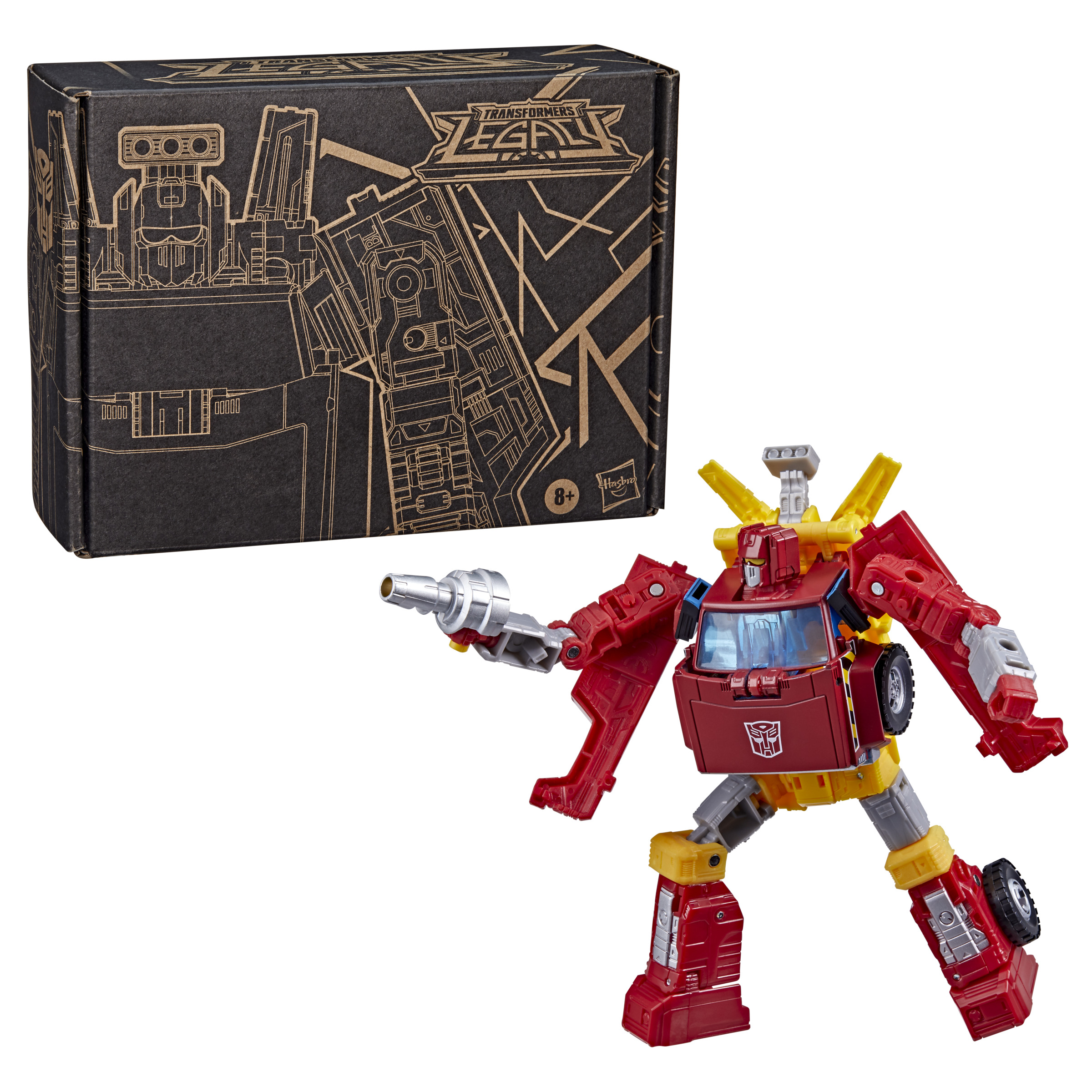 Un robot de Transformers rojo y amarillo con un bláster, posando frente a su caja de embalaje.