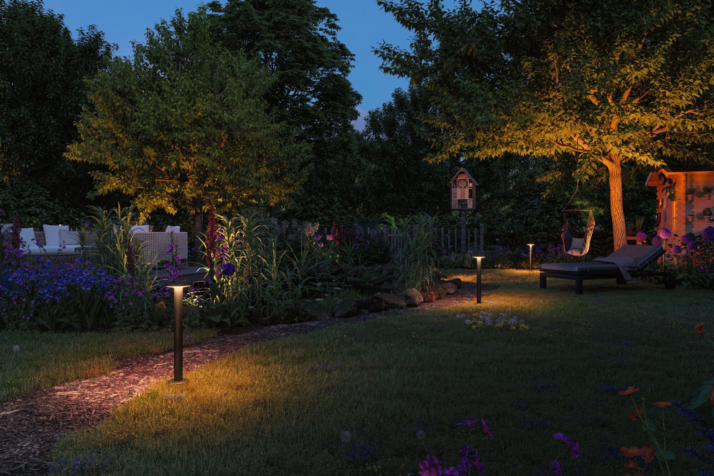 Nachtszenen Garten mit Lichtern, Bäumen und Sitzbereich.