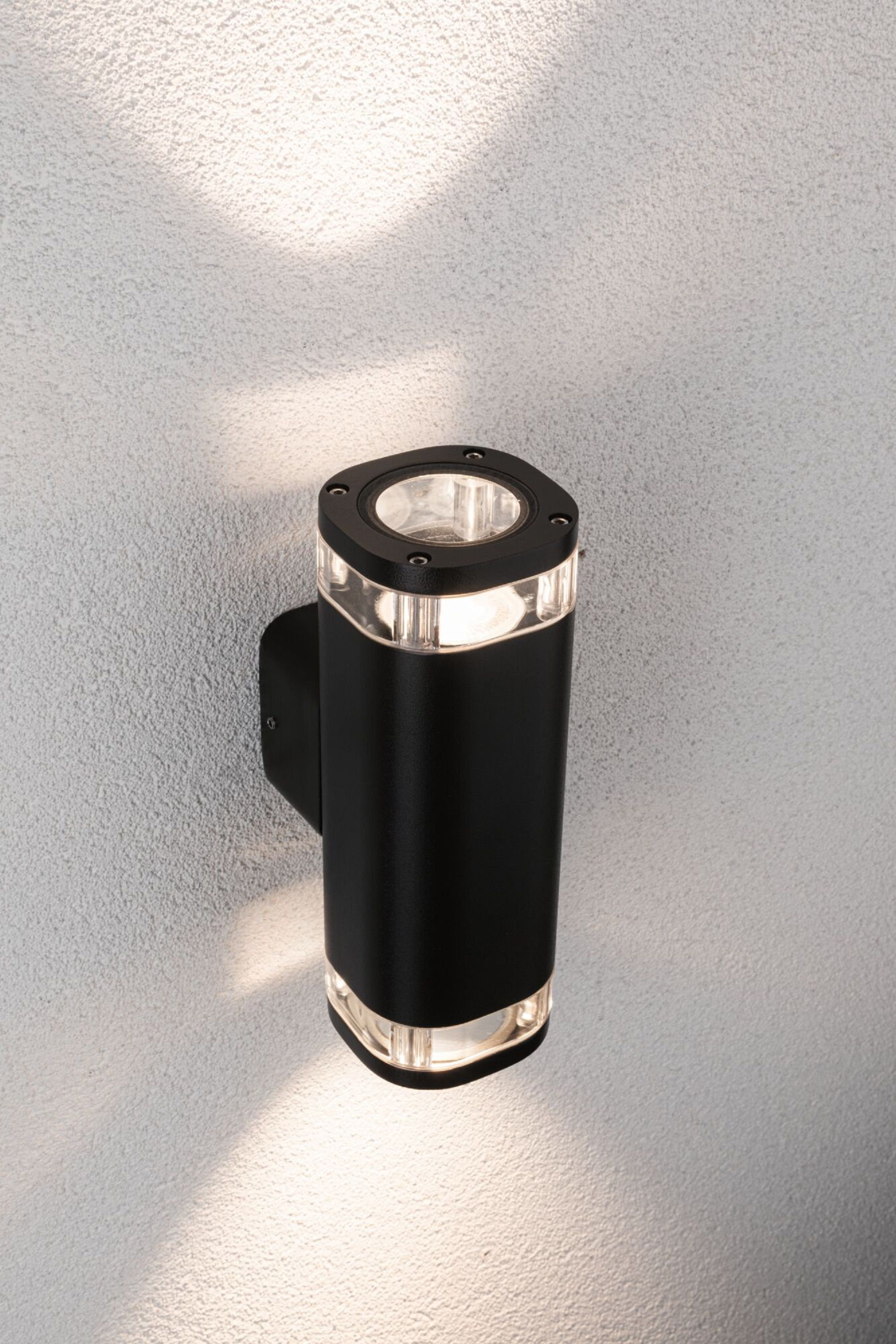 Schwarze Außenwandleuchte mit Doppellicht, an einer strukturierten Wand montiert.