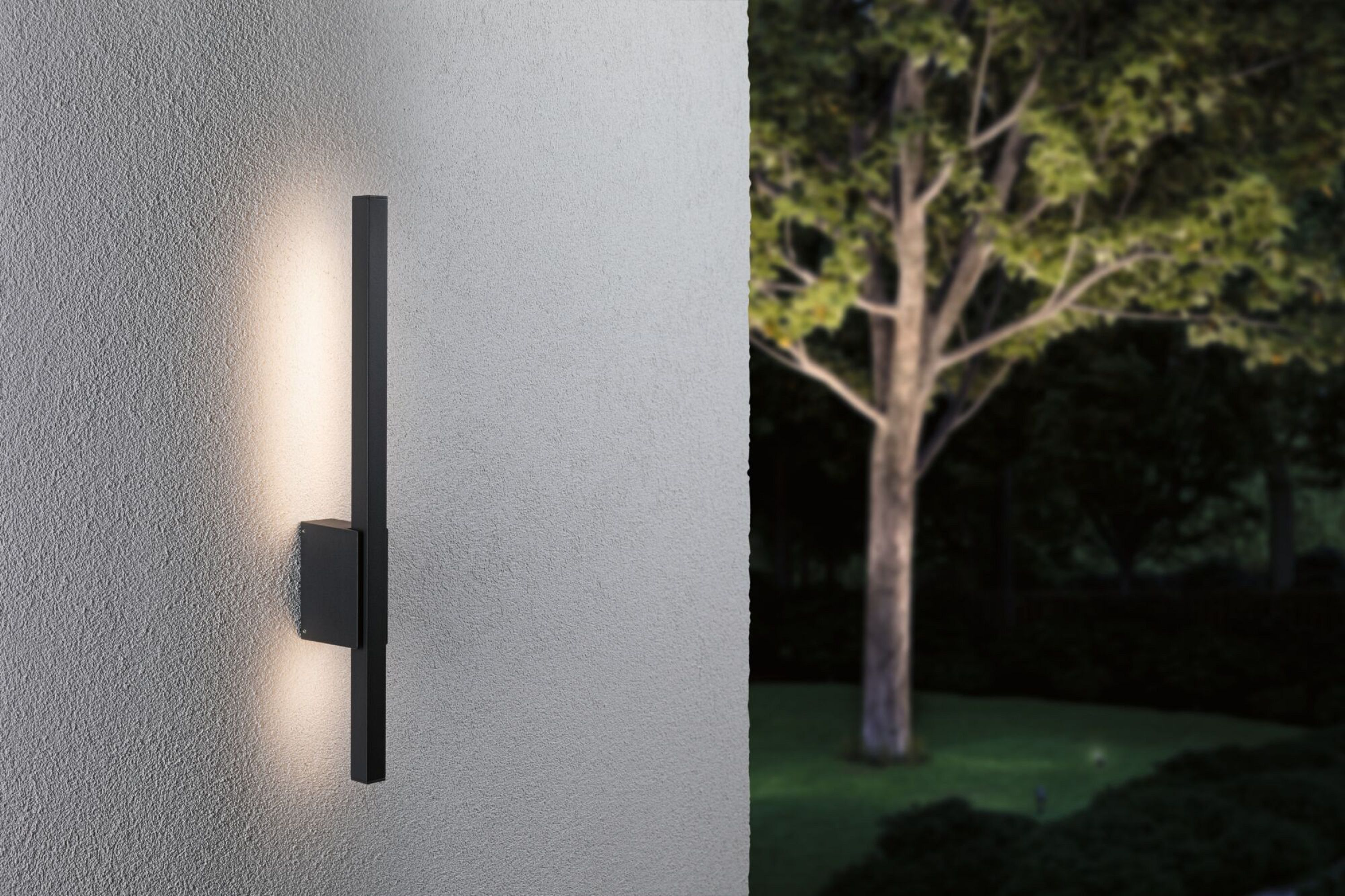 Schwarze Außenwandleuchte, die Licht emittiert, an einer Wand montiert.