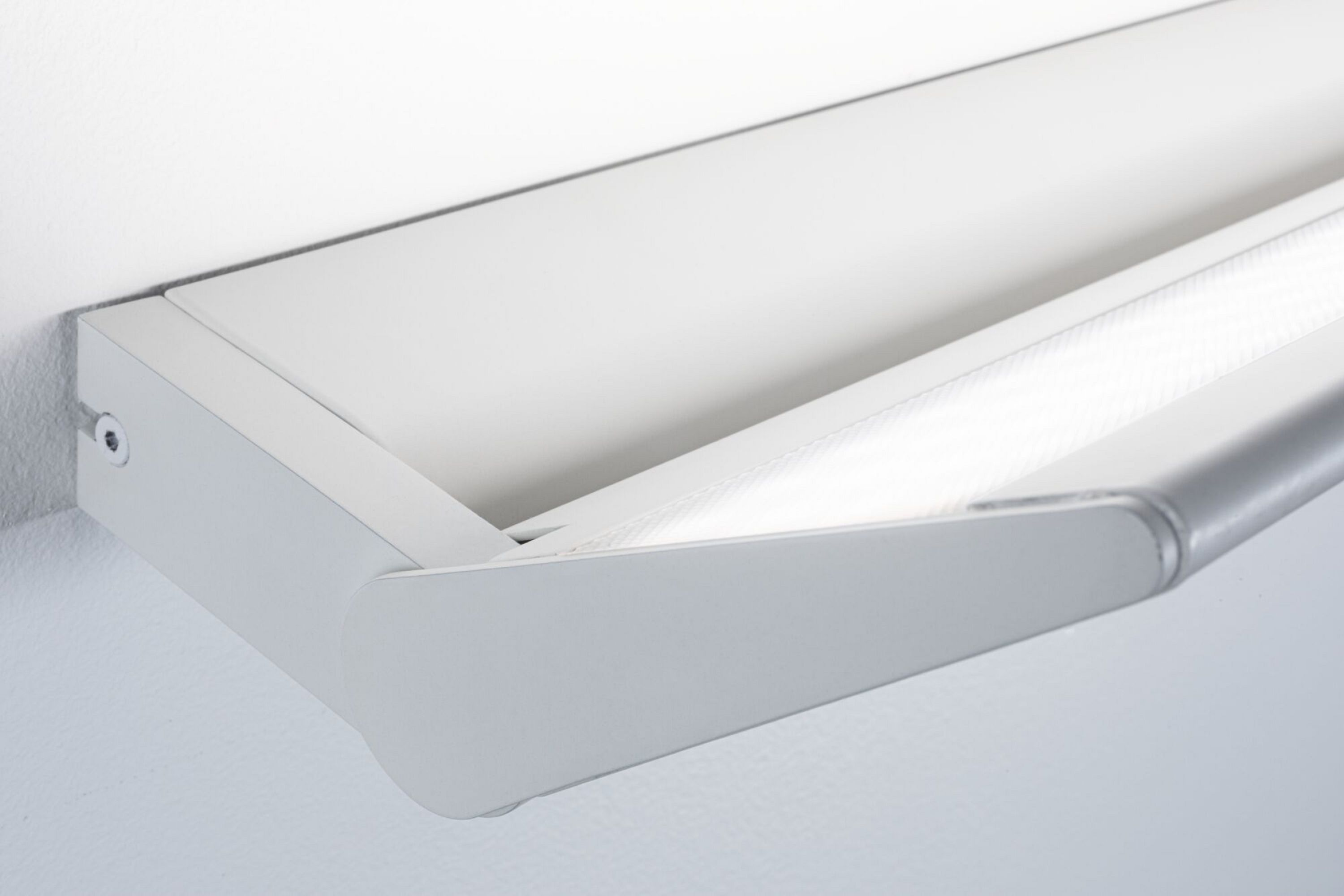 Weiße Wandleuchte mit geschwungenem Design. Weißer Hintergrund.