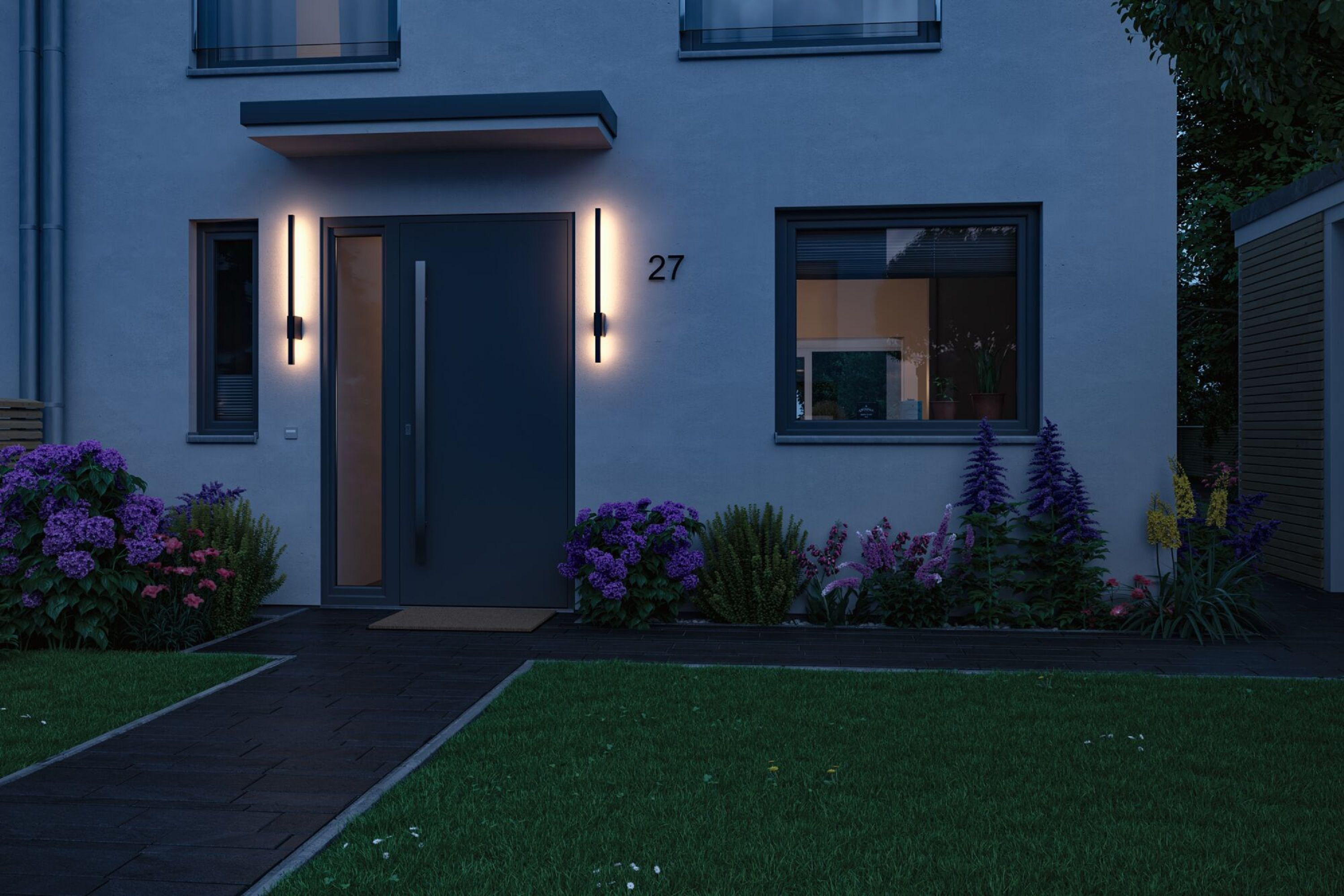 Hausfassade bei Nacht mit Lichtern, einer Tür und beleuchteter Hausnummer 27.