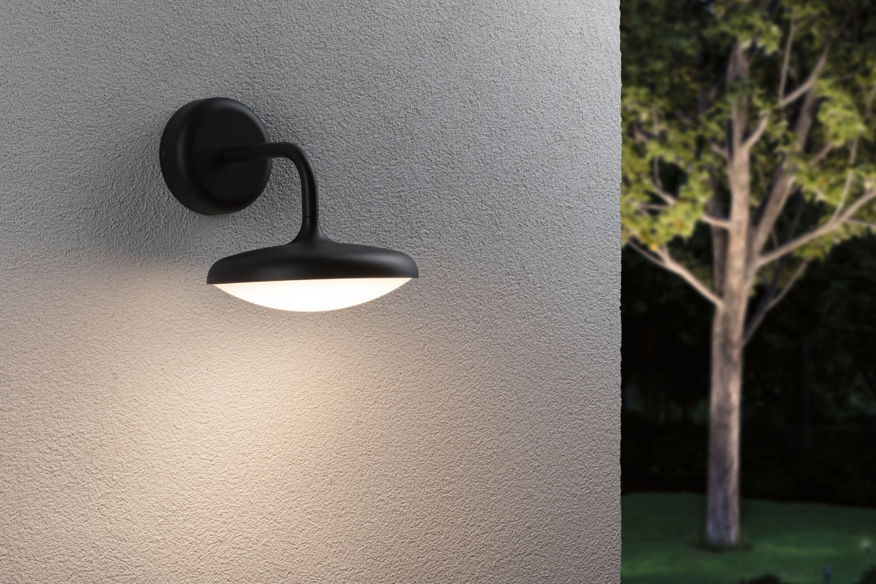 Schwarze Außenwandleuchte mit Licht, montiert an einer strukturierten Wand.