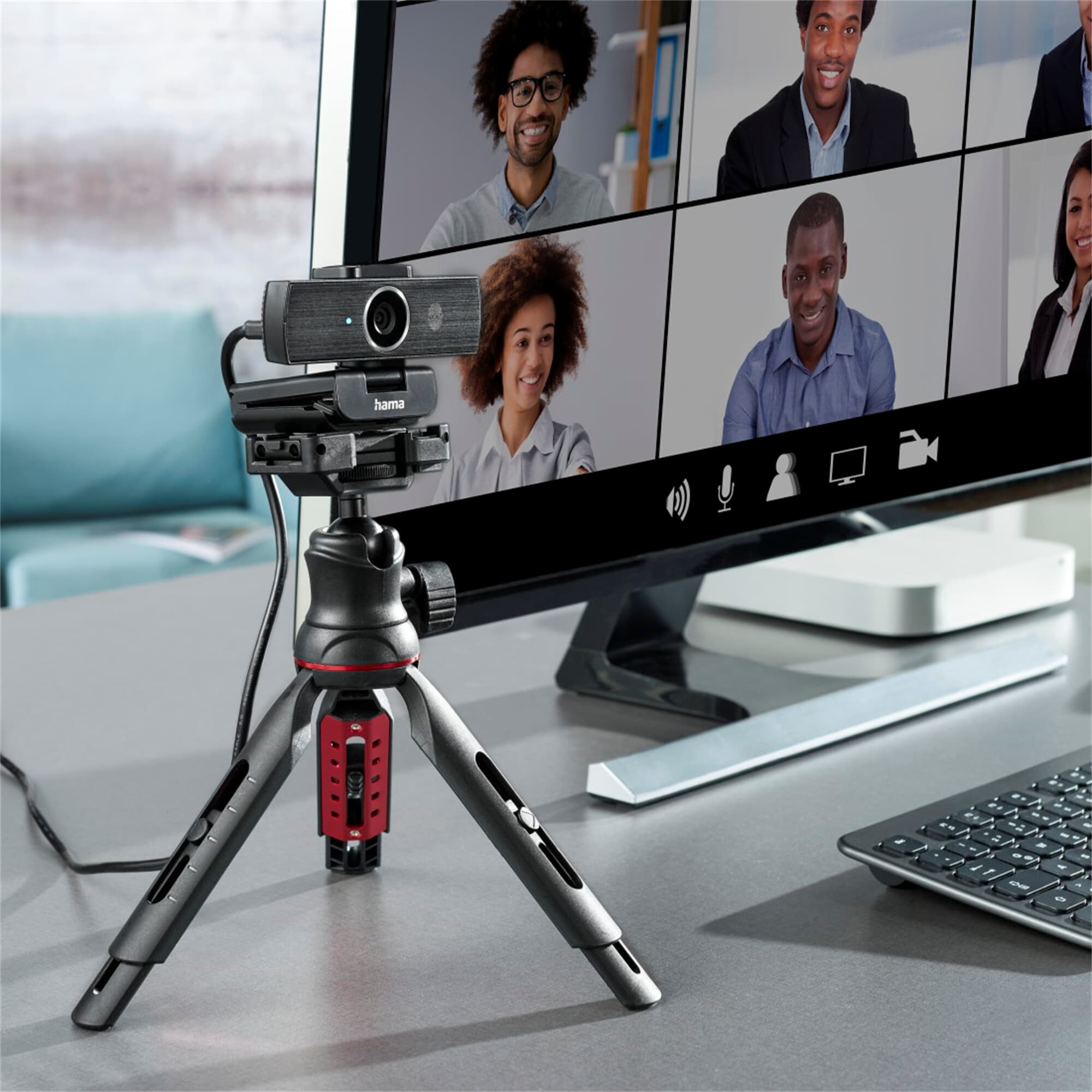 Webcam su un treppiede, con un monitor che mostra persone in una videochiamata.