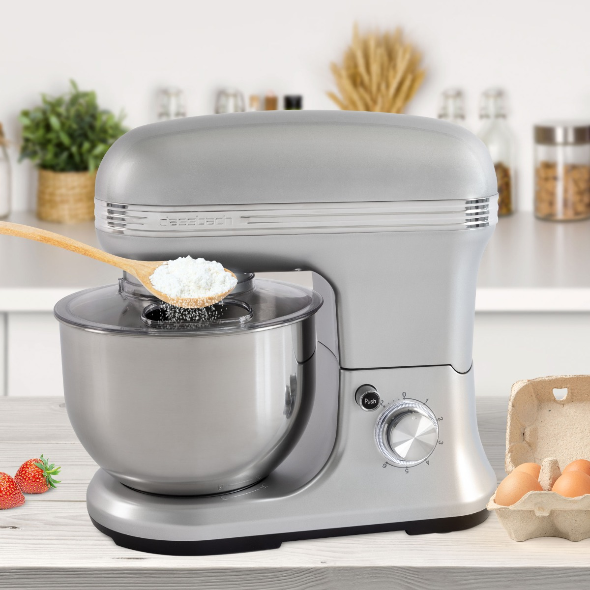 Szary mikser z mąką wlewaną do miski. Widoczne truskawki.