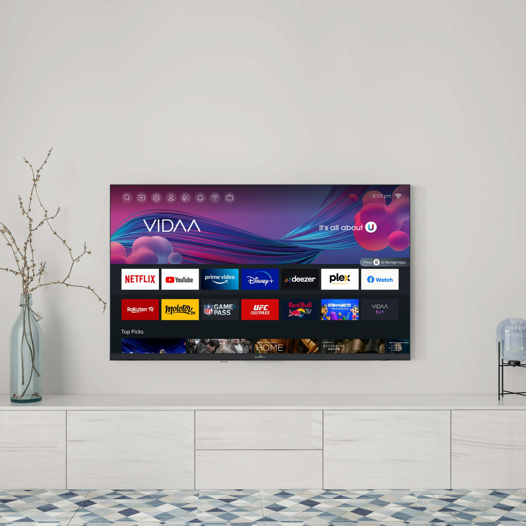 Telewizor wyświetlający różne ikony aplikacji, zamontowany na białej szafce, z dekoracjami.