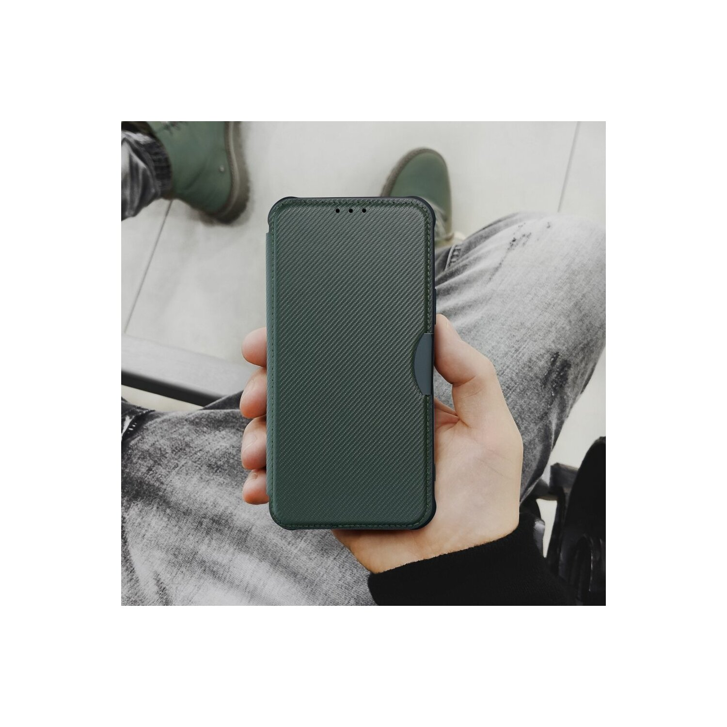 Mano che tiene una custodia per telefono verde scuro, seduta sulle ginocchia di una persona.