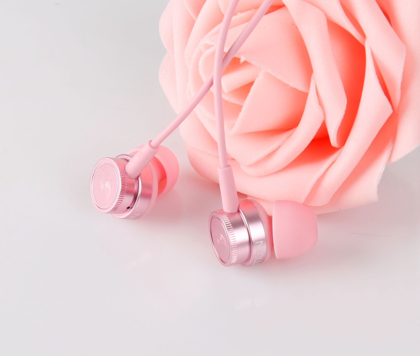 Rosa Ohrhörer mit floralem Hintergrund, die Details der Ohrhörer und eine weiche Ästhetik zeigen.